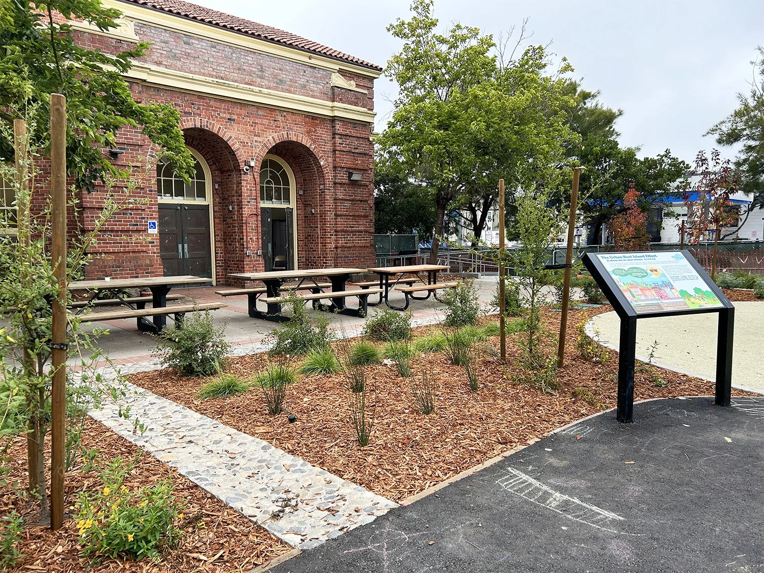 Learning areas extend beyond the school building, using interpretive signage and natural materials to engage students with ecology and sustainability.