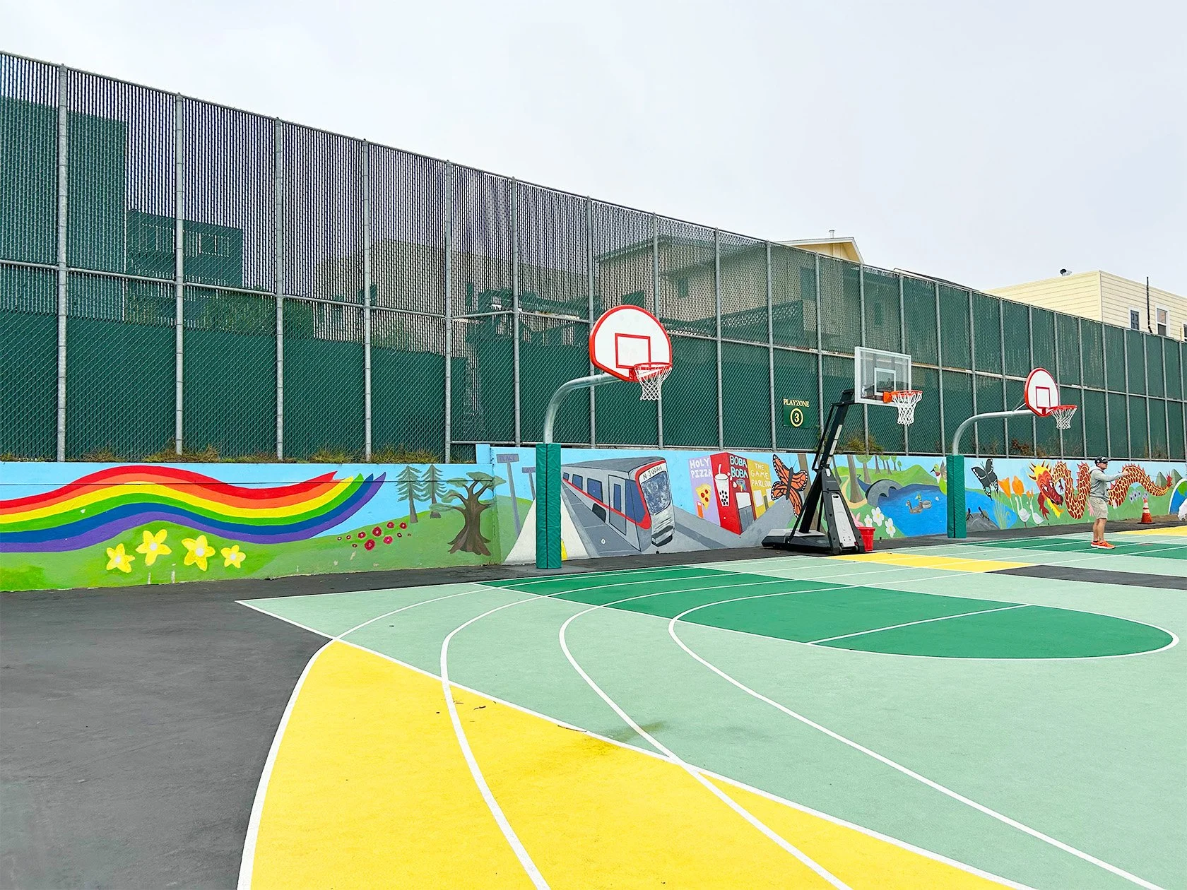 Brightly-colored court surfaces and community-inspired artwork bring energy and identity to shared recreation spaces.