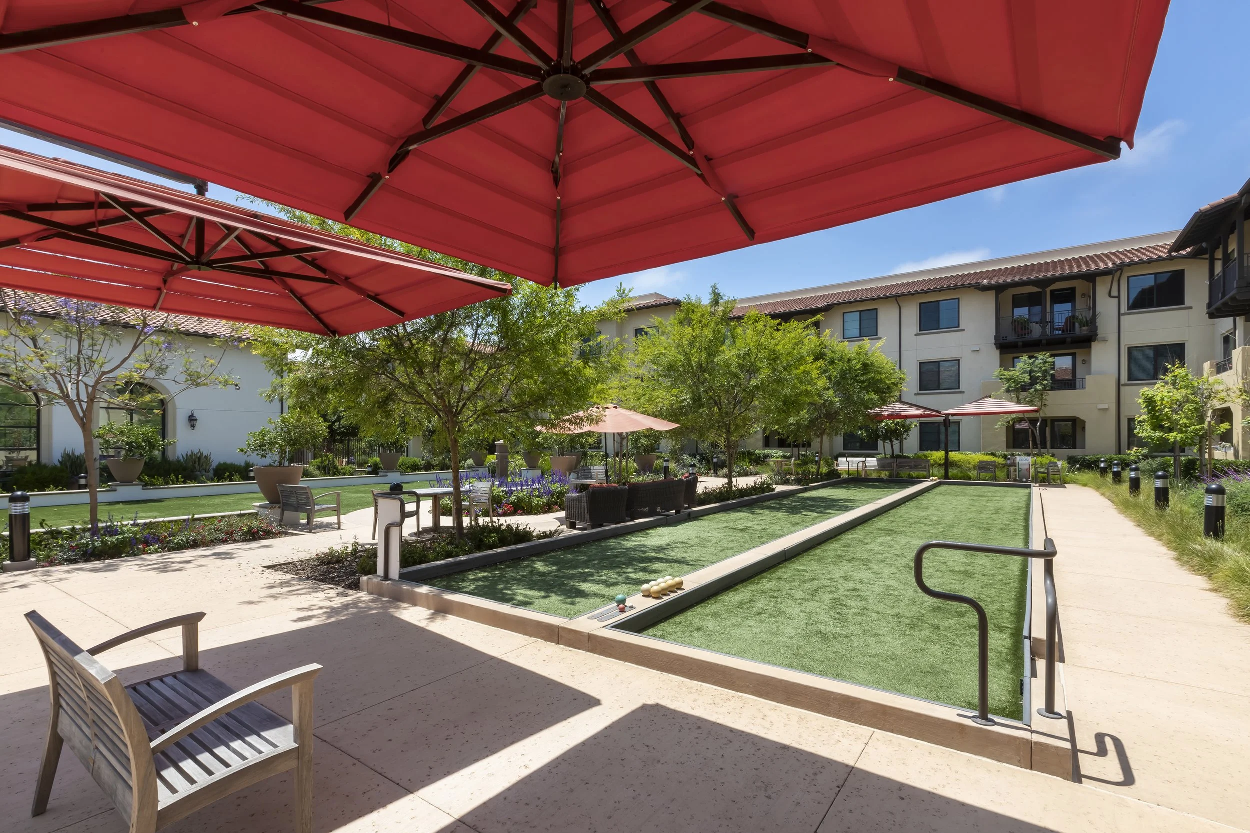 Shaded seating areas surround bocce courts and a yoga lawn activating social spaces