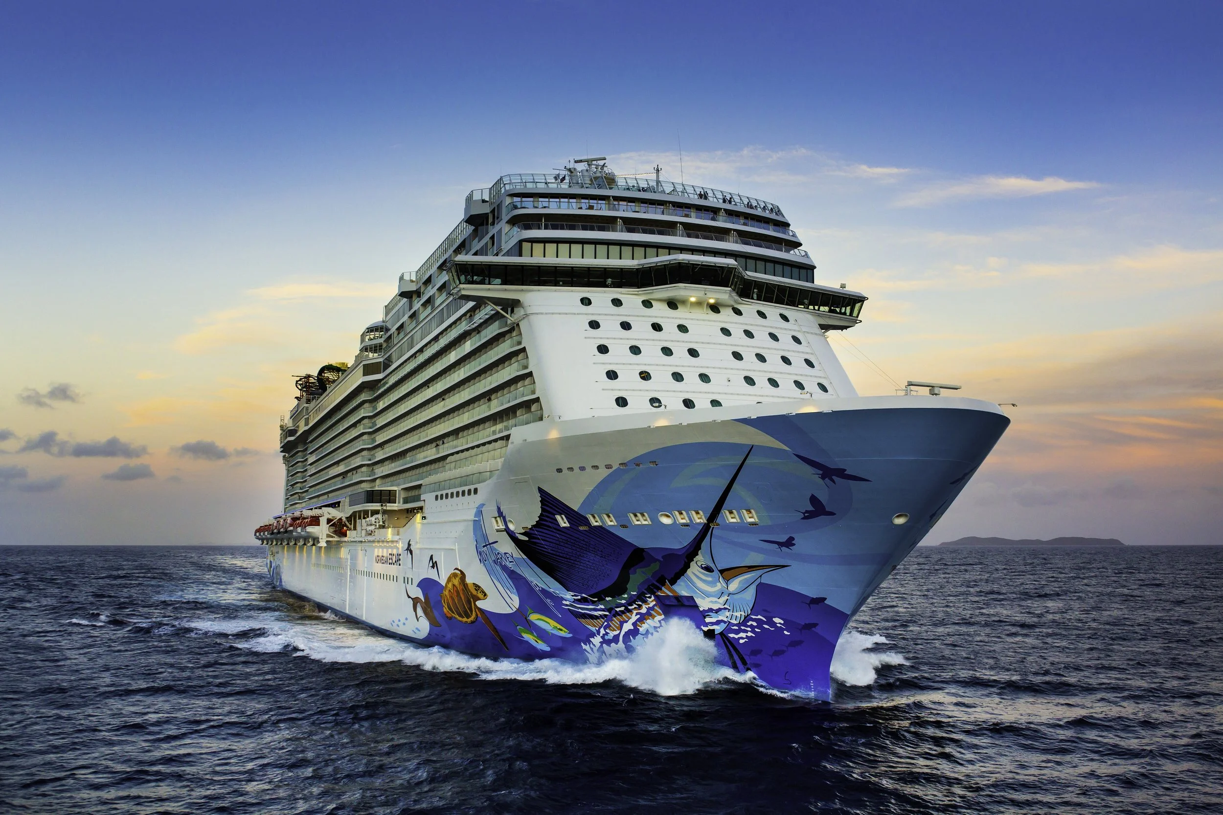 Large cruise ship sailing on the ocean during sunset, with a colorful whale and whale tail painted on its hull.
