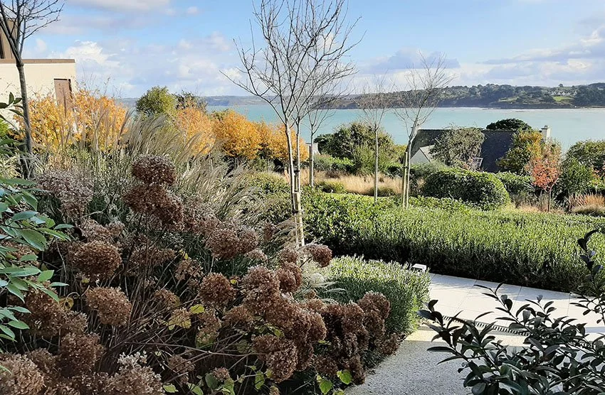 Aménagement de jardin en bord de mer dans le Finistère avec vue sur la baie et végétation adaptée au littoral.