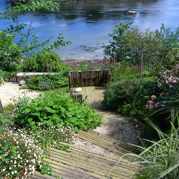 Aménagement d'un jardin en pente avec terrasses, escaliers et vue sur l'estuaire du Guindy en Bretagne