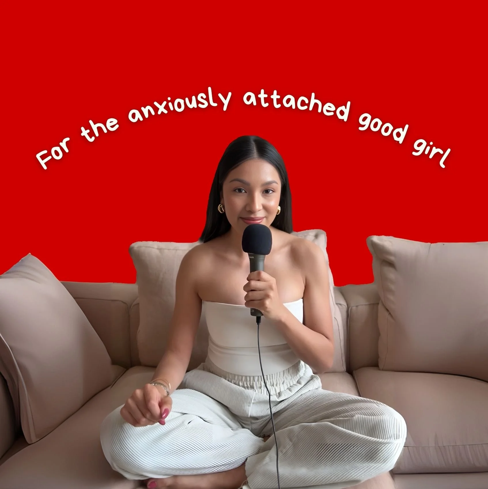 A young woman with long dark hair, sitting on a beige couch, holding a microphone, smiling, and looking at the camera with a red background and text that reads 'For the anxiously attached good girl'.