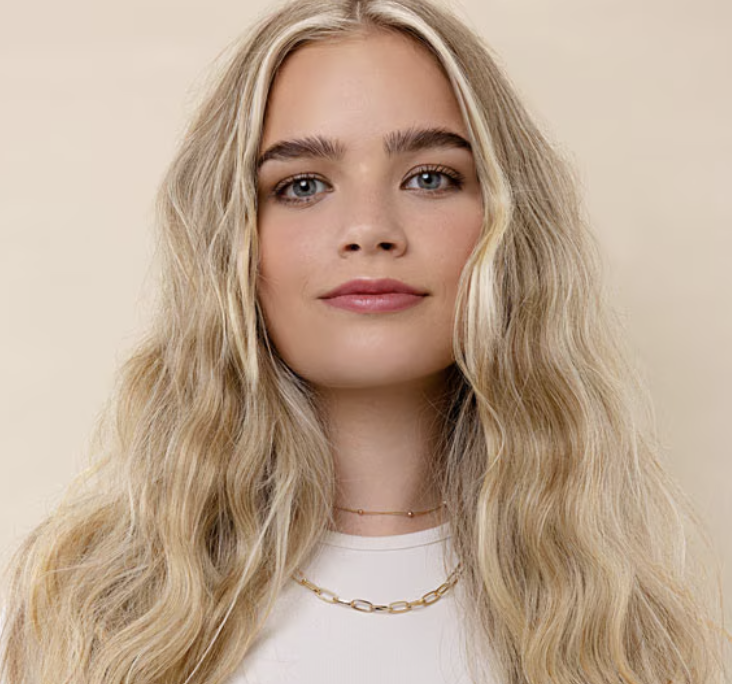 Woman with long blonde hairstyle who just received a haircut and color