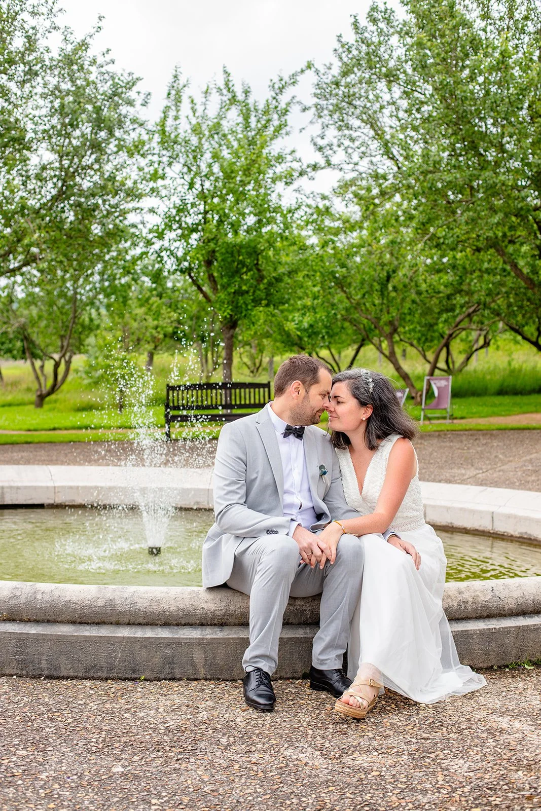 Nous deux pendant notre séance photo de couple, en tenue de mariage, au bord d’une fontaine