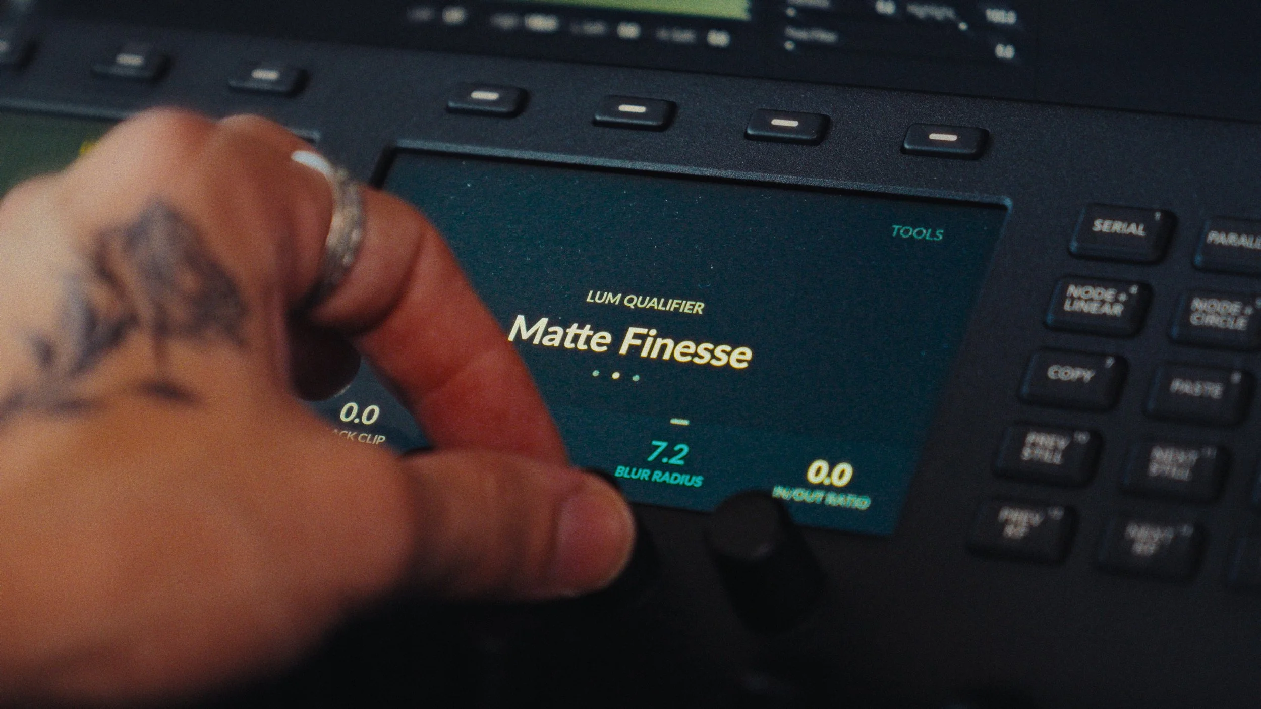 Close-up of an audio mixing console screen displaying the matte finesse setting for a lamp, with a person's hand adjusting a knob.