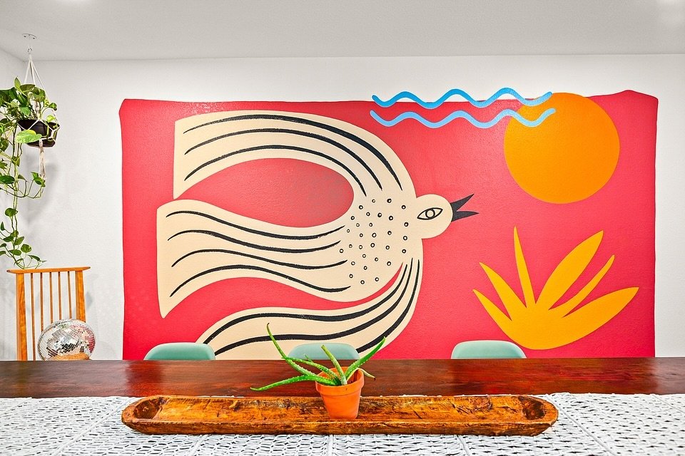 Bold, bright, and brimming with personality 🌞 
Howdy Renovations transformed this dining space into a vibrant retreat, complete with a custom mural that brings the outdoors in! 🍃 From the playful pops of color to the eclectic mix of seating, every 