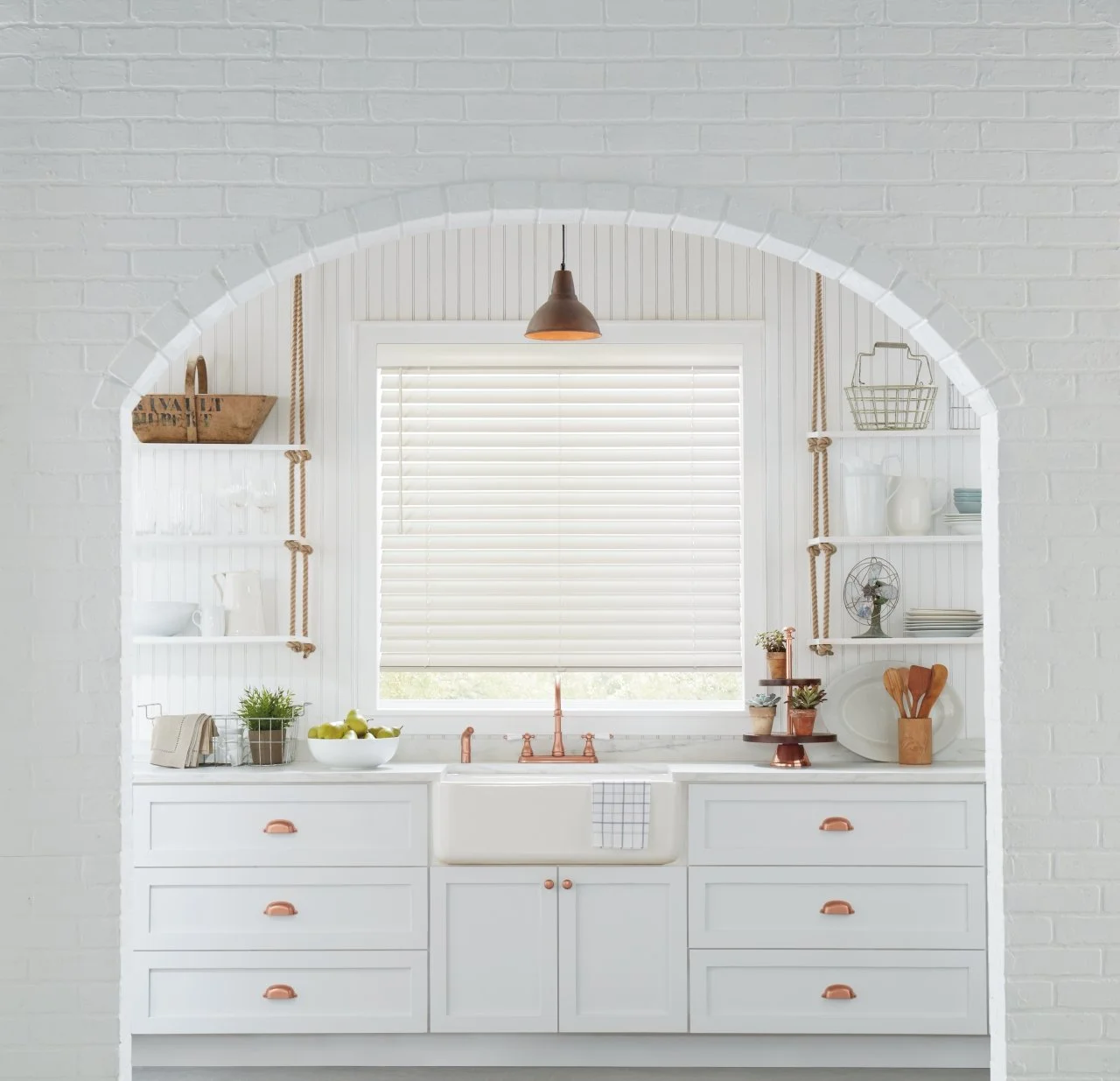 Bright white kitchen with open shelving and a large window featuring Hunter Douglas window shades