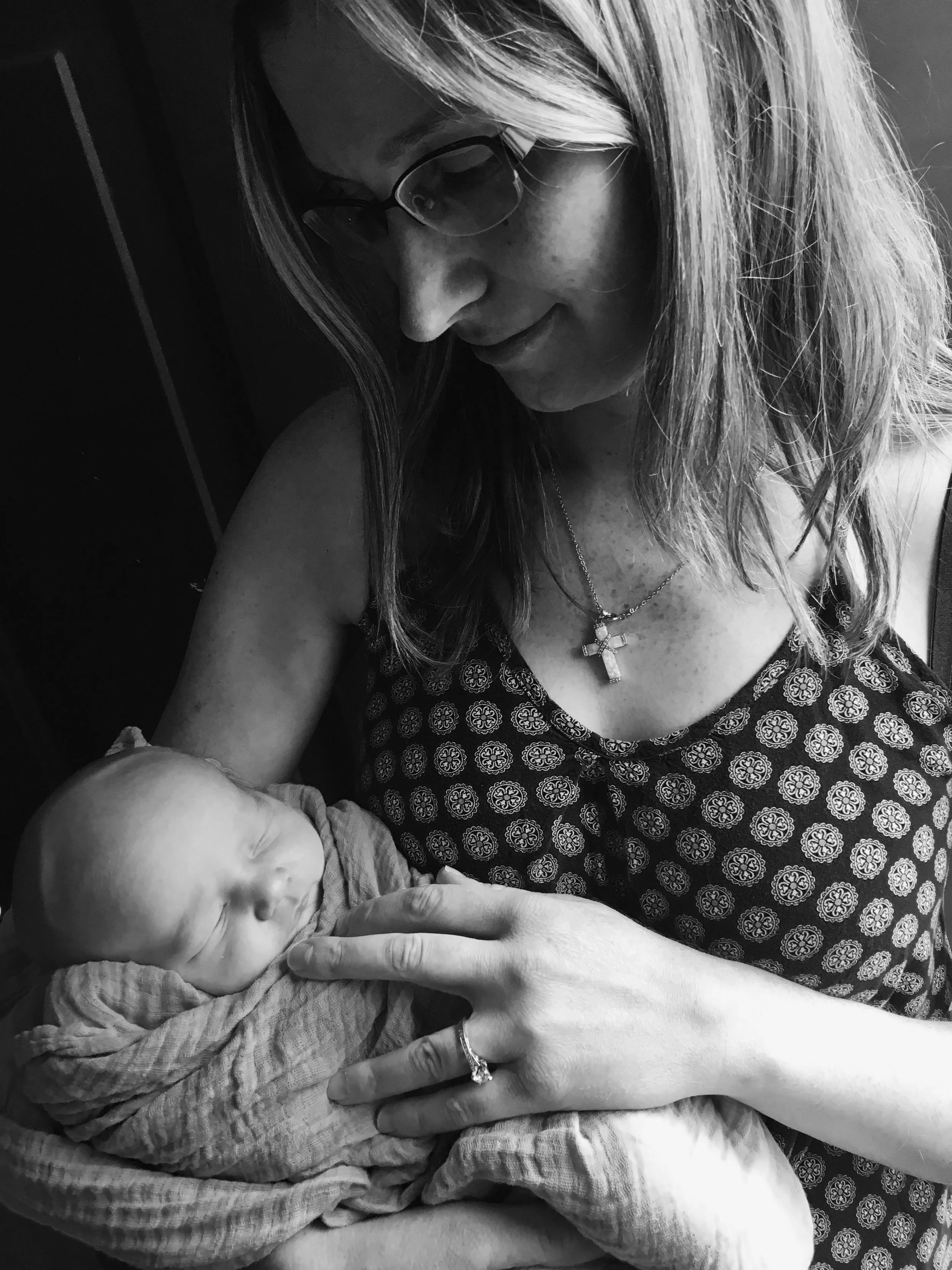 Black and white portrait of young mother gazing admiringly at her infant son.