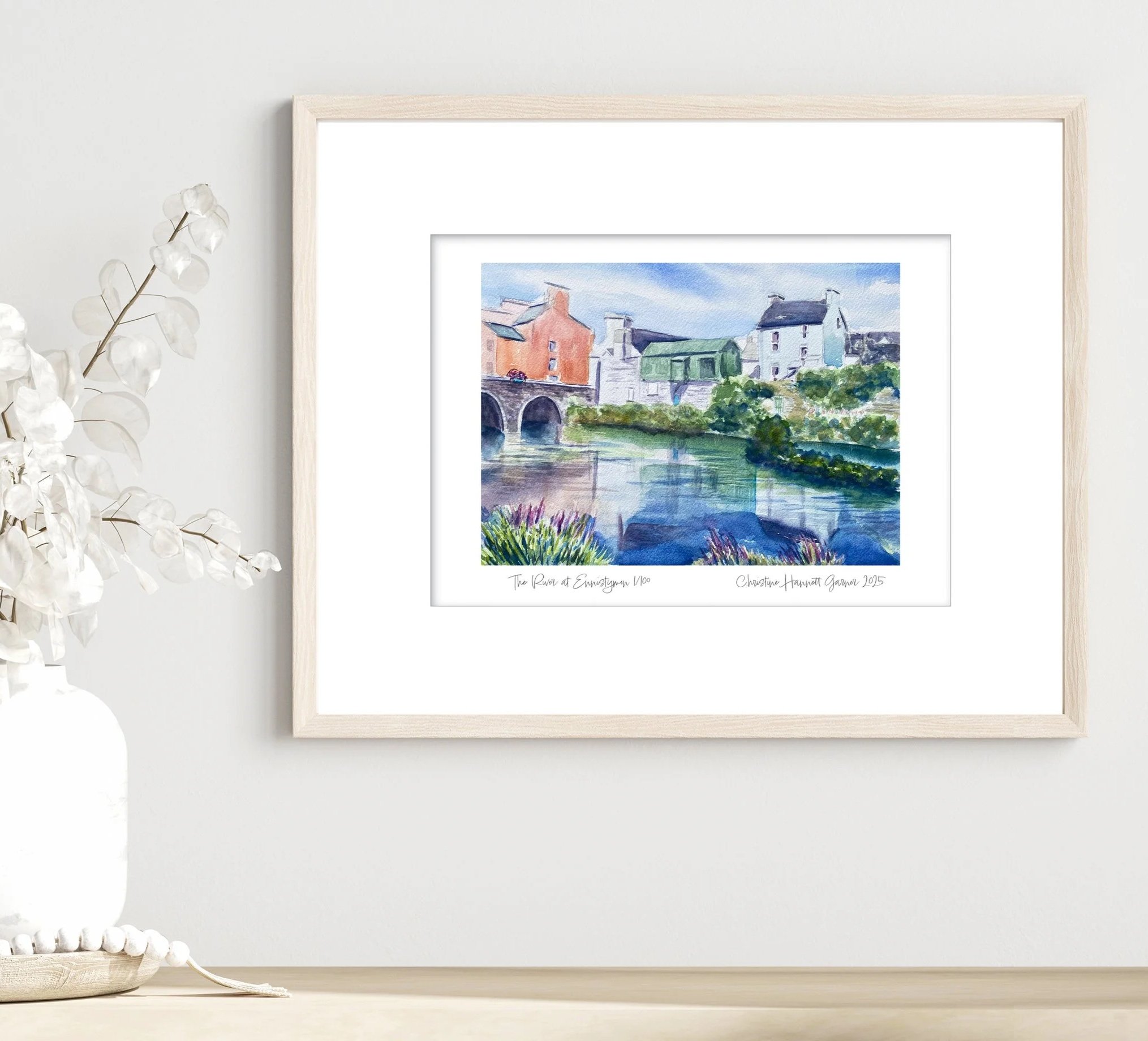 Framed art print of the "River at Ennistymon" watercolor painting featuring historic buildings and the bridge to Ennistymon, Ireland reflected in the river.