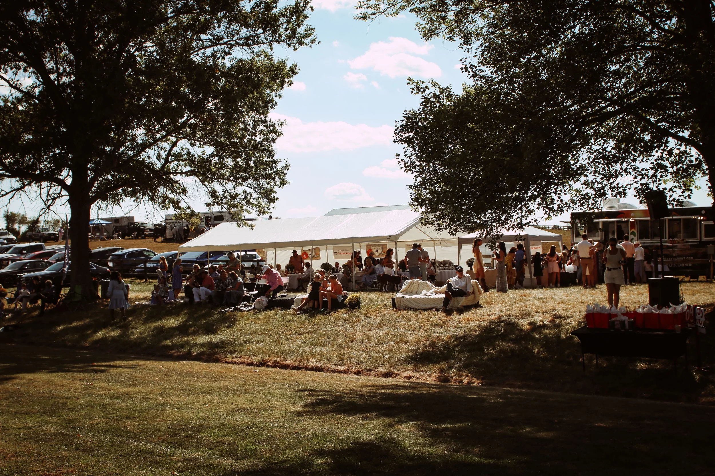 Event attendees at the 2025 Charity Polo Cup spectating from seats near a tent.