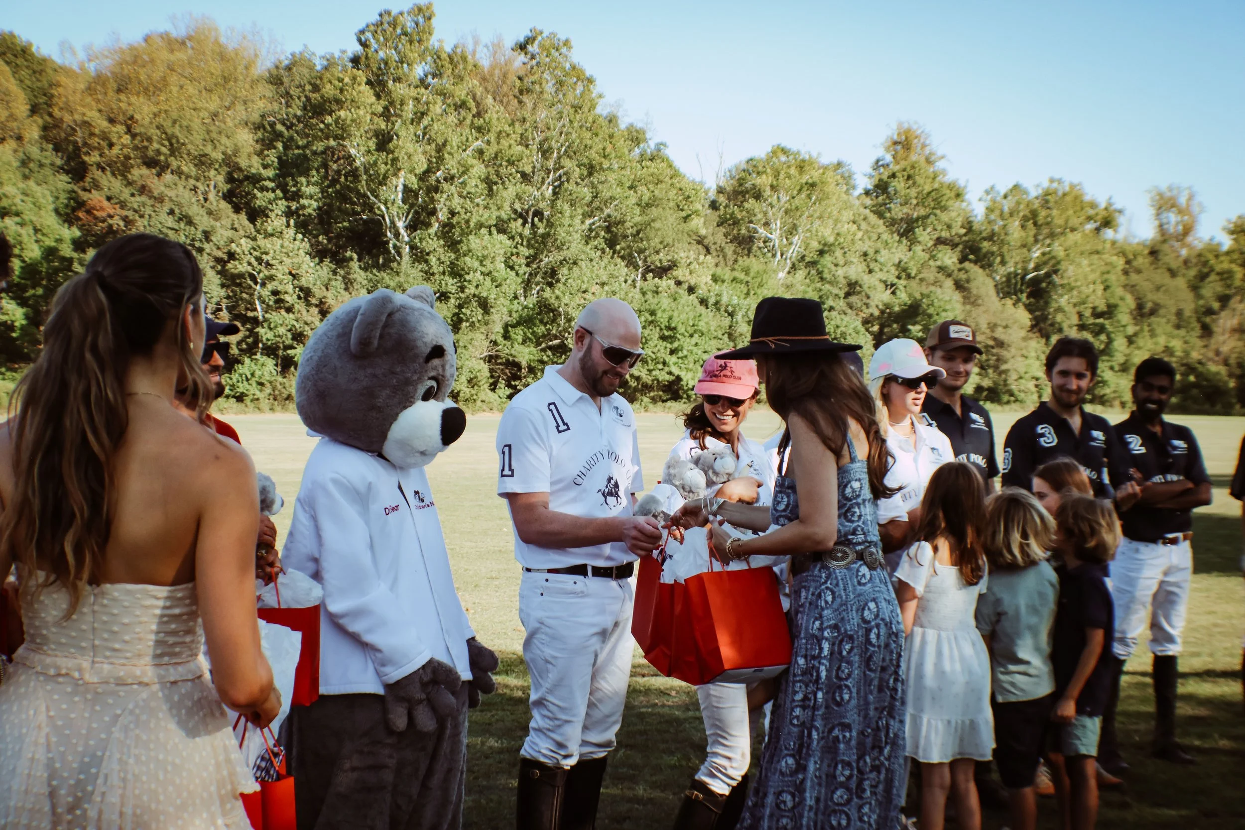 A member of the Founders Auxiliary distributes prizes to players post-match at the 2025 Charity Polo Cup.