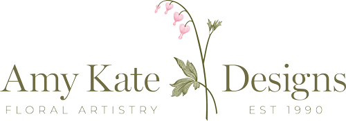 Logo for Amy Kate Designs featuring illustration of pink flowers and text "Floral Artistry Est 1990."