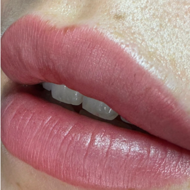 Close-up of lips with smooth pink lipstick.