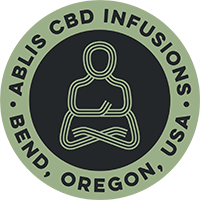 Logo of Abilis CBD Infusions with a Buddha figure and text, located in Bend, Oregon, USA.
