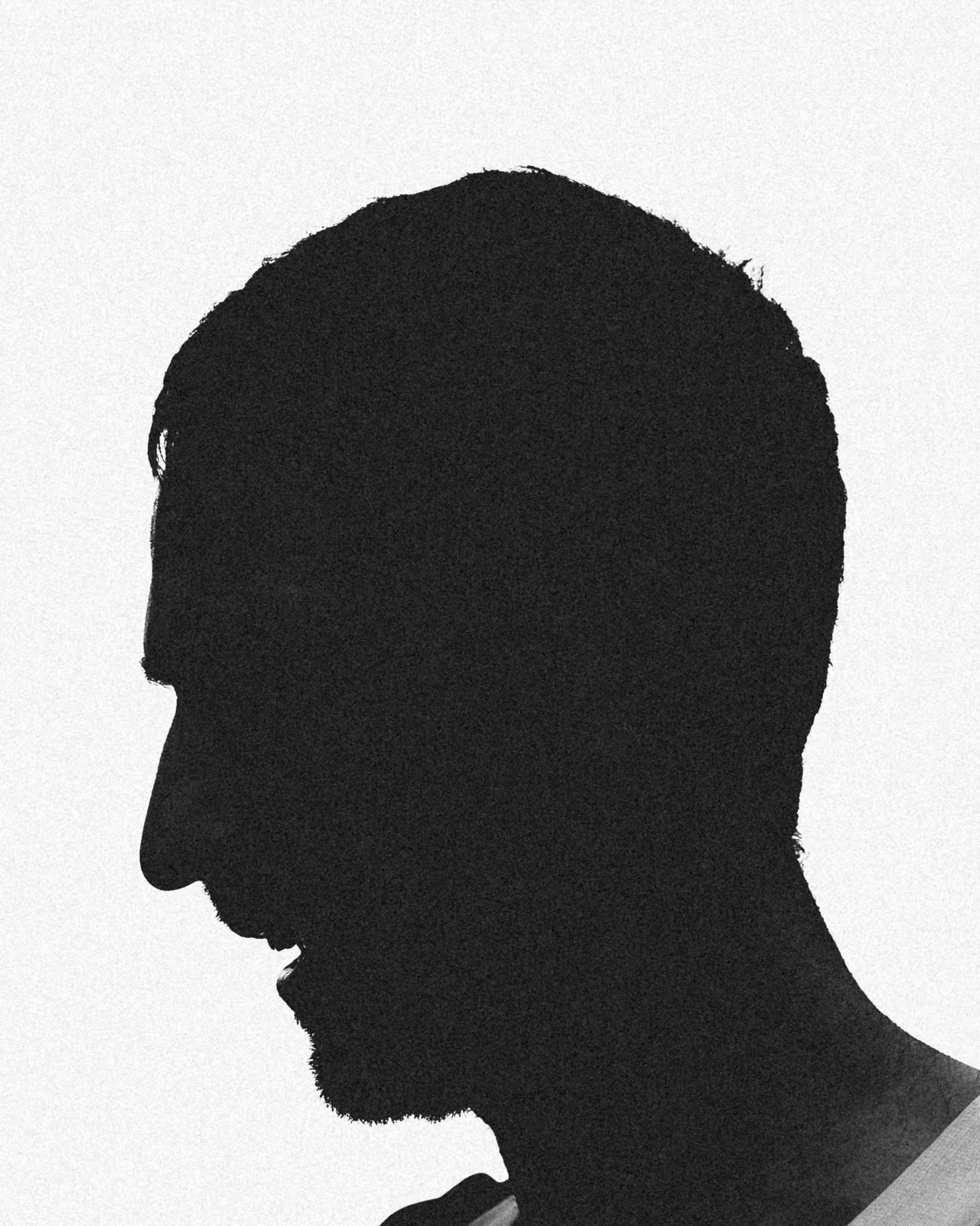 Silhouette of a person's face in profile with short hair, set against a light background.
