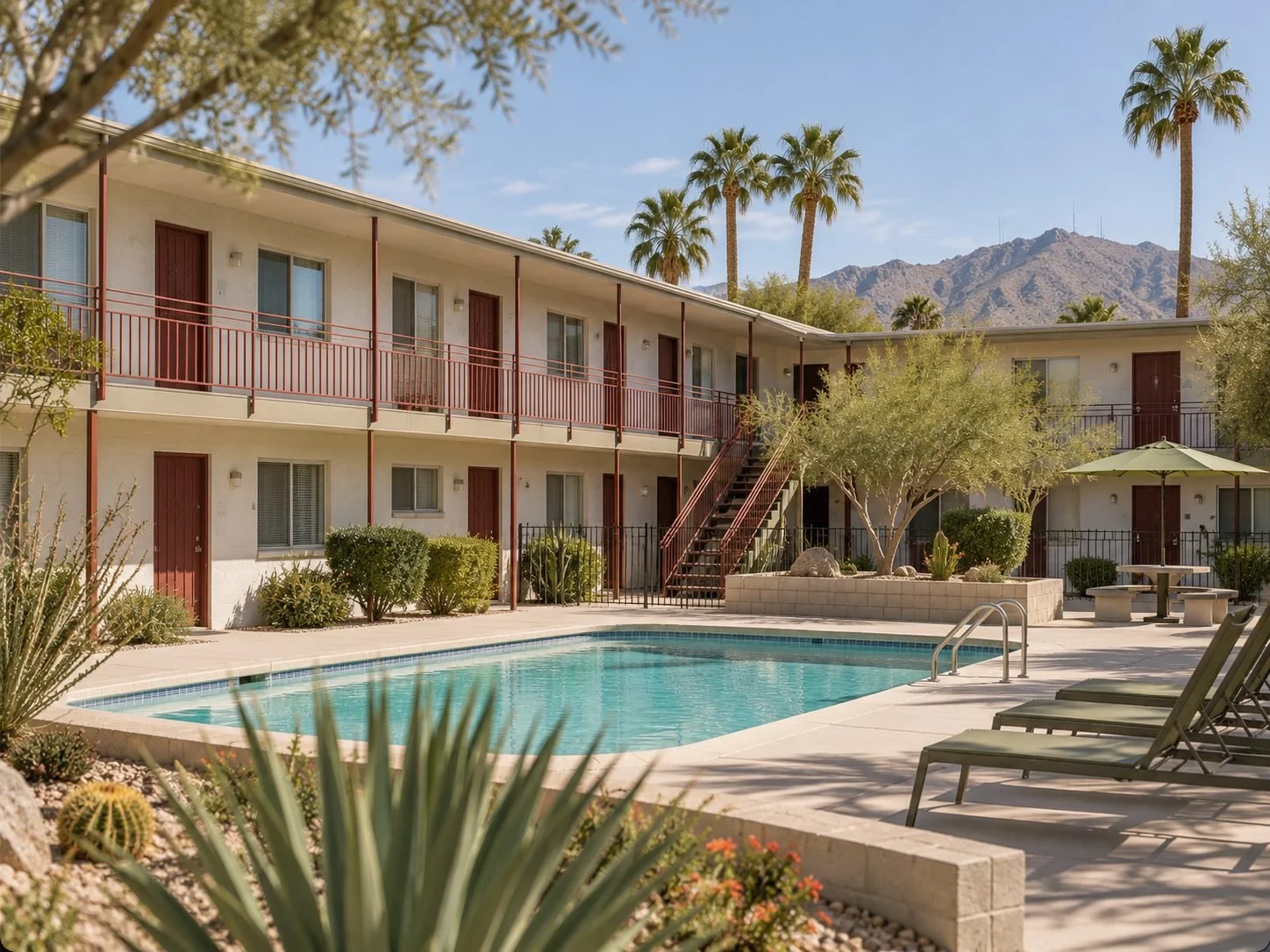 Two-story Broadway Village apartment building with a pool and palm trees in Midtown Tucson
