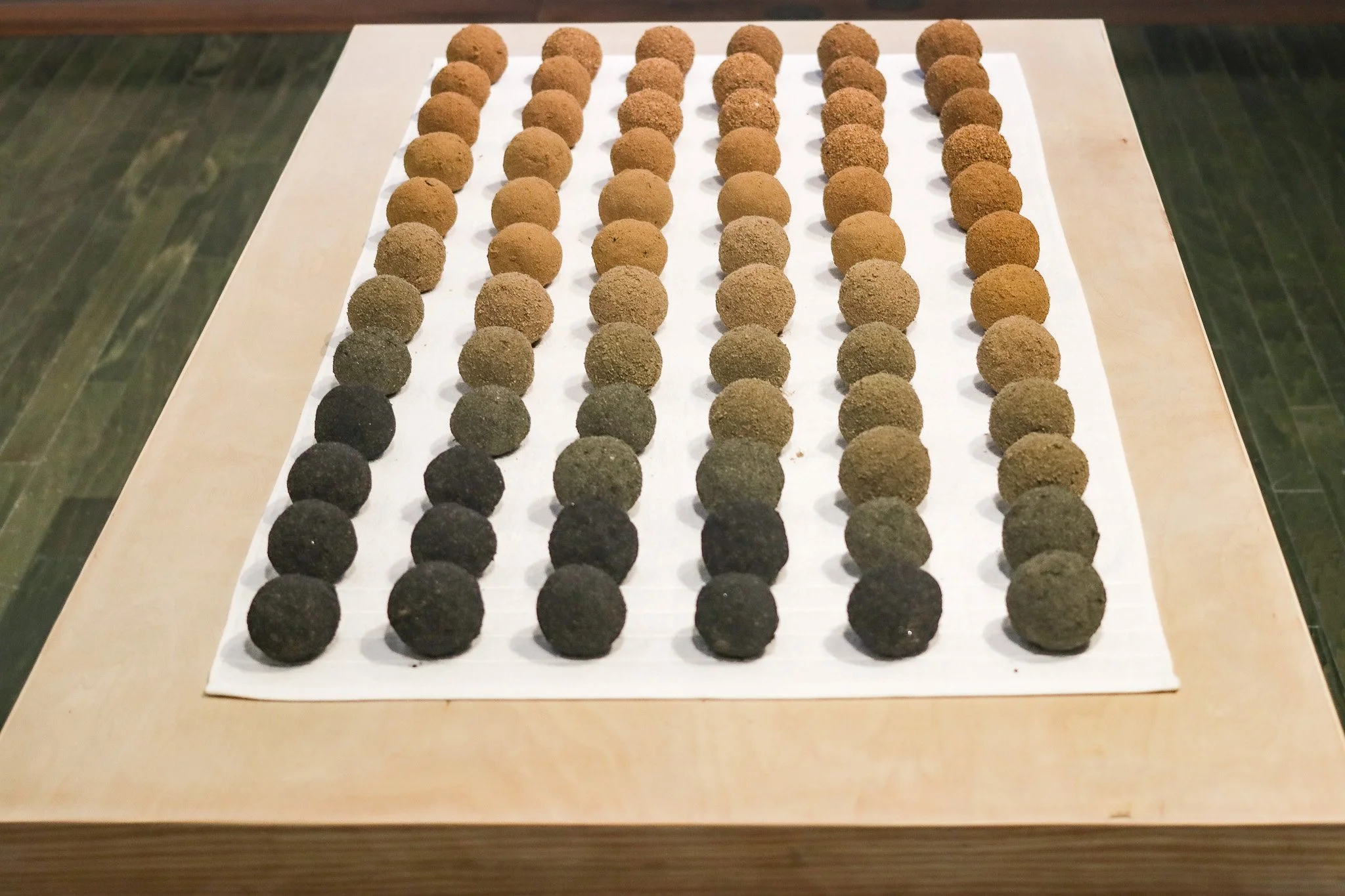 Tropical Blizz Ball Sale: After David Hammons (Gradient) | 2025 | sand, towel & wood | 74” x 40” x 30.5” 