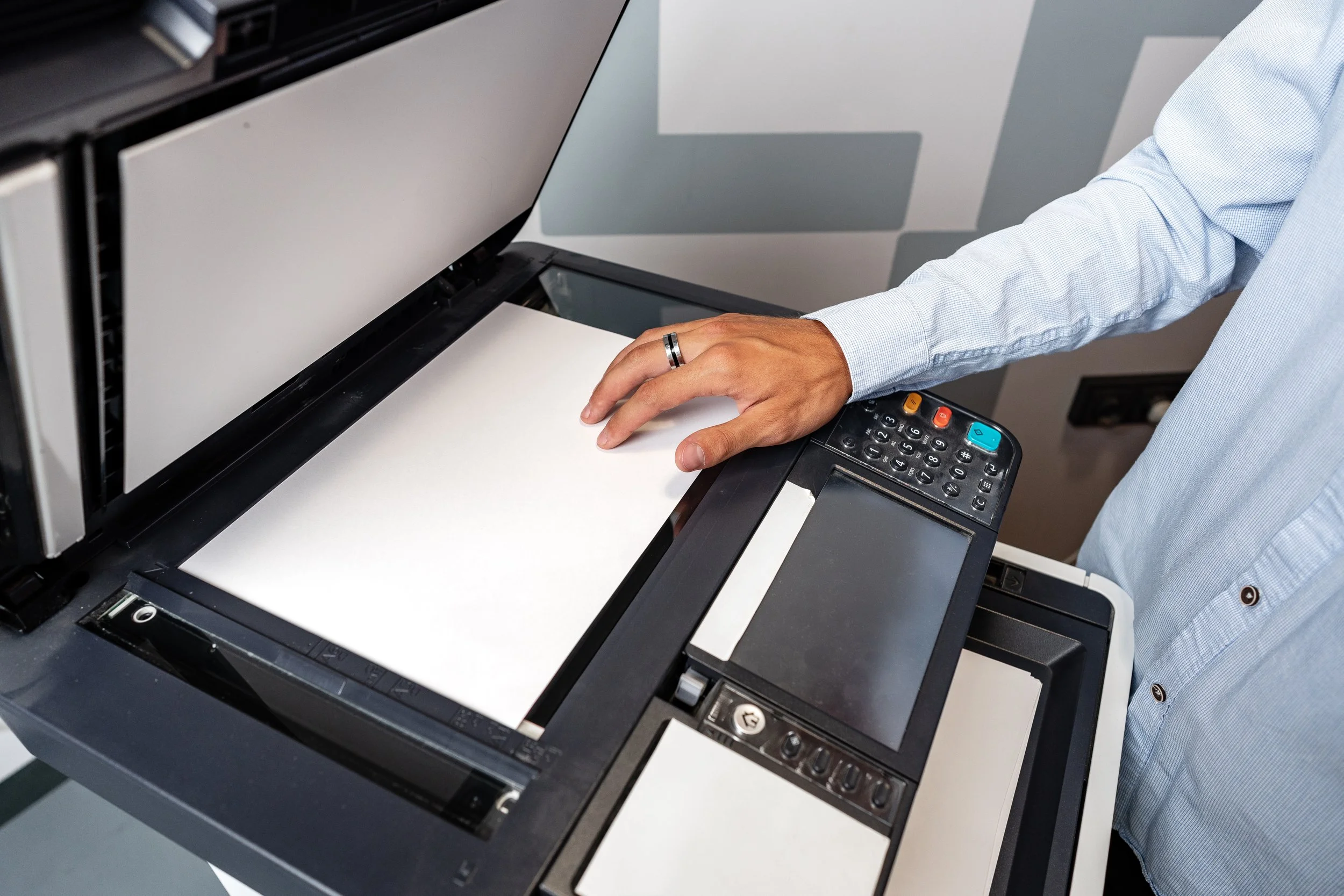Person using a modern photocopier to make a copy of a document