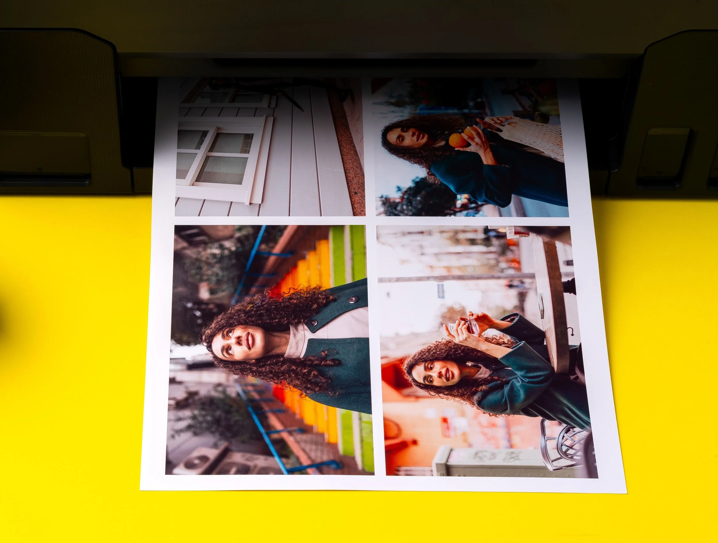 Photograph of a printout with four pictures of a woman with curly hair in various outdoor settings, including a park and city streets.