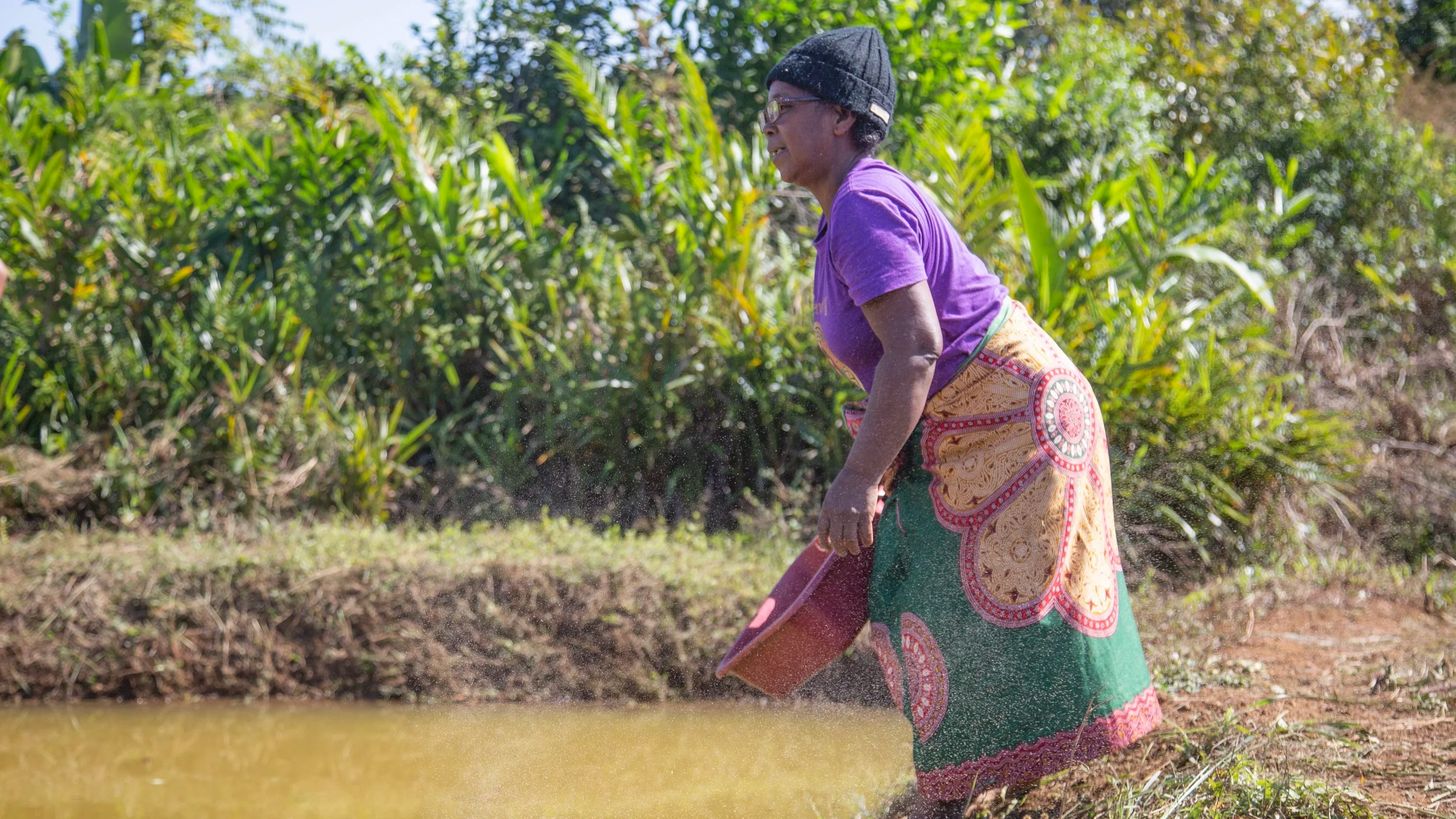 woman with plastic tub near pond in Madagascar