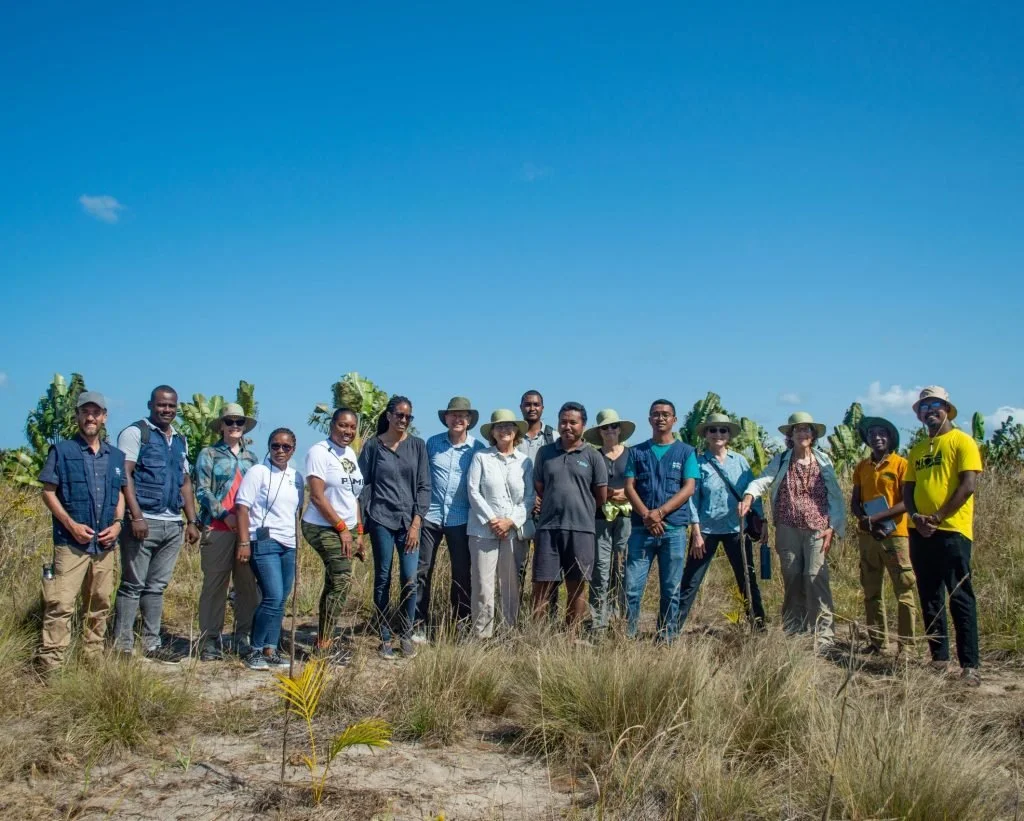 HIH Madagascar team members, HIH Global partnerships team, and donors pose together for a photo in a reforestation site.