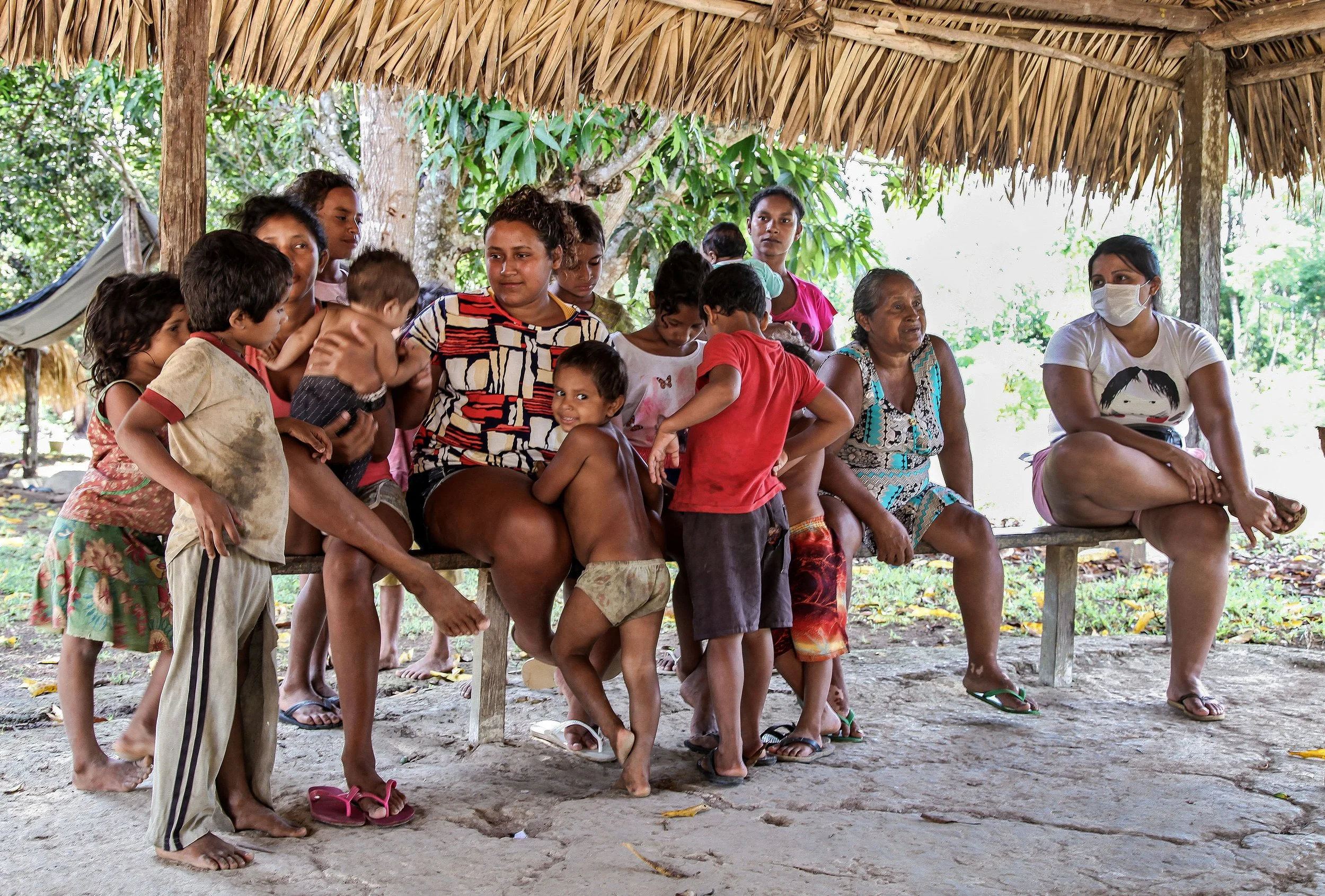 Women, clildren, and the elderly gather in an outside structure in RESEX Morro Grande, Brazil