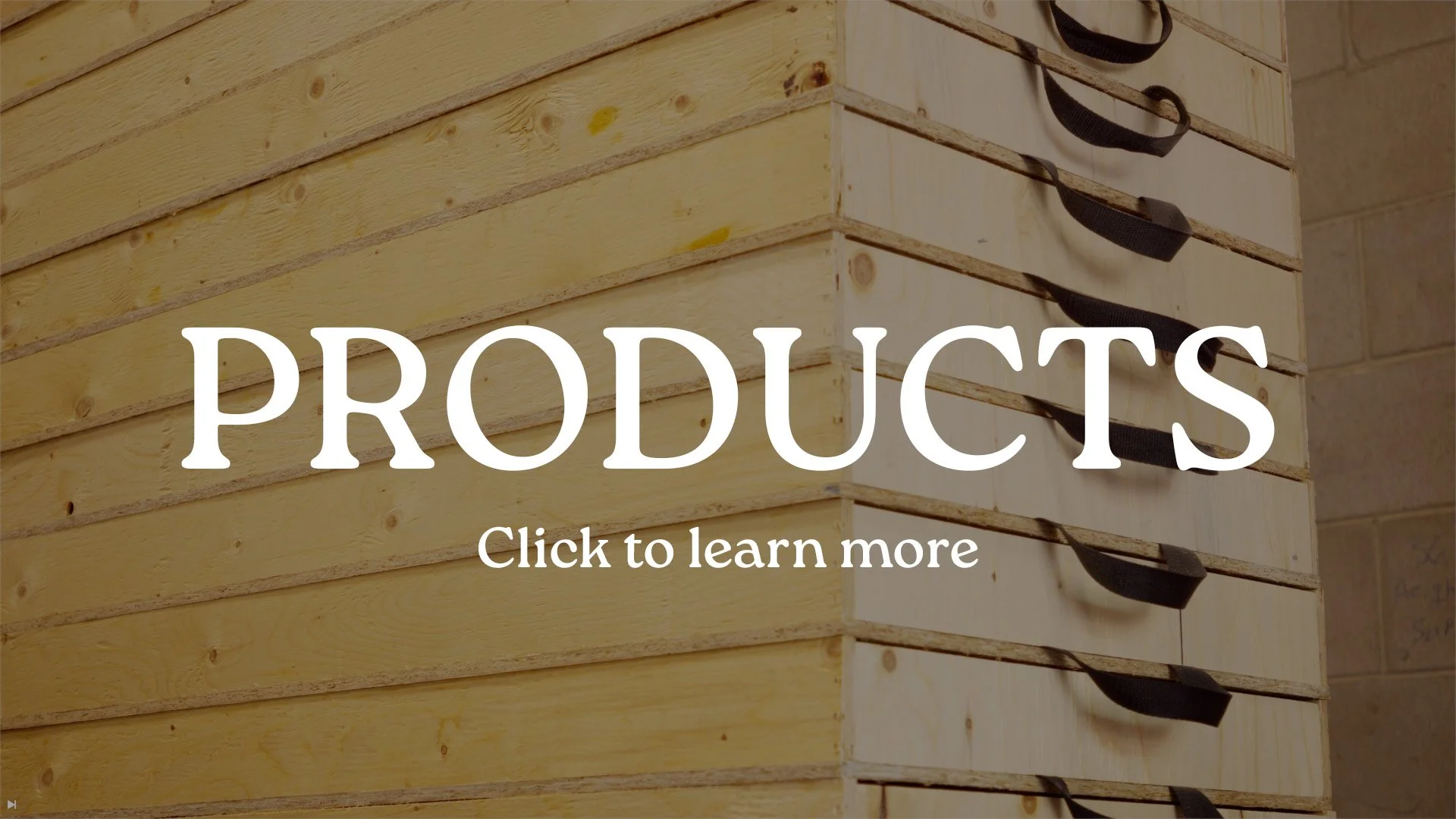 Stacked wooden pallets with black straps, on a brick wall background, with white text overlay reading 'PRODUCTS' and 'Click to learn more'.