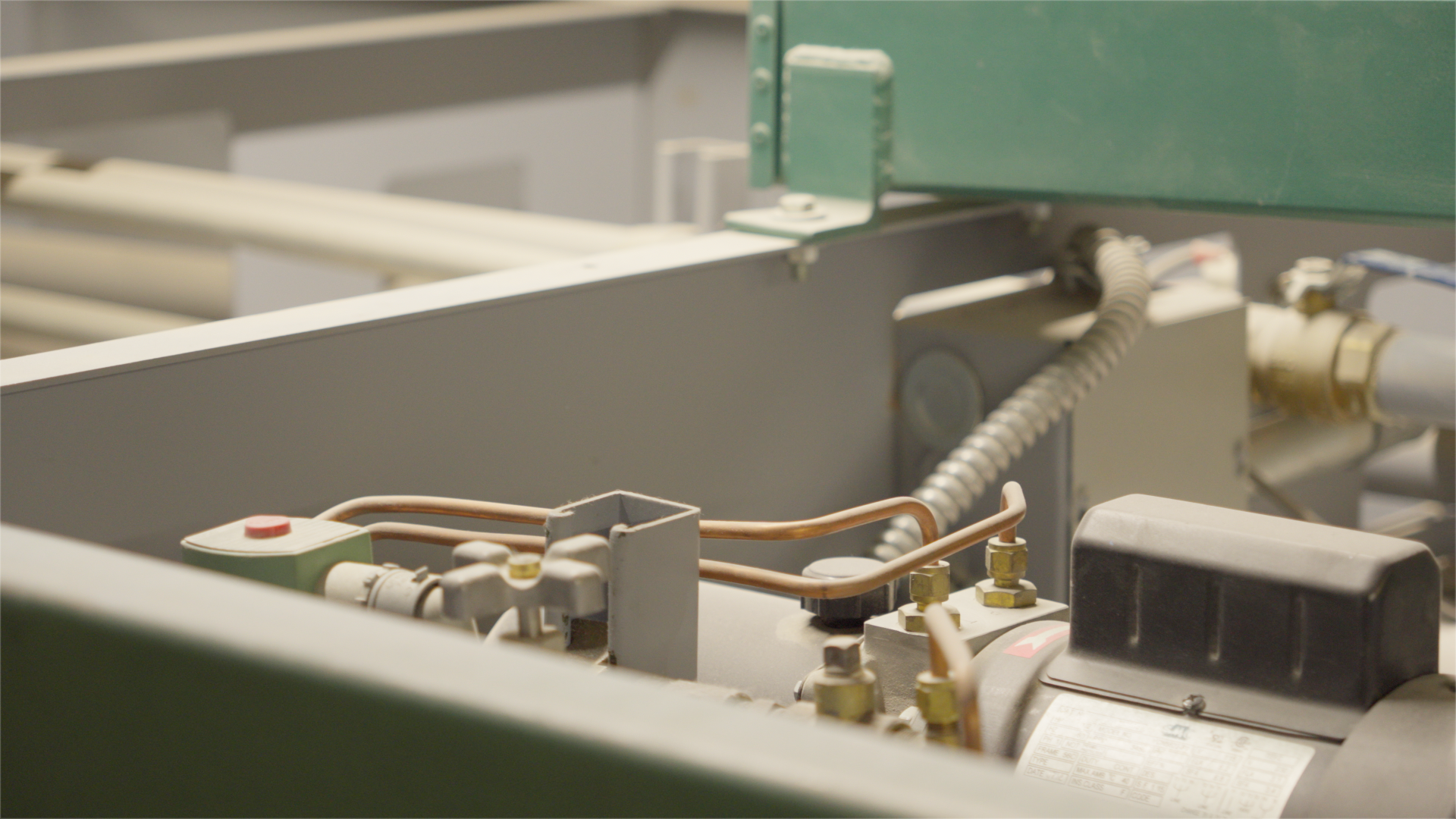 Close-up of electrical or mechanical components with wires, pipes, and metal parts inside equipment or machinery.