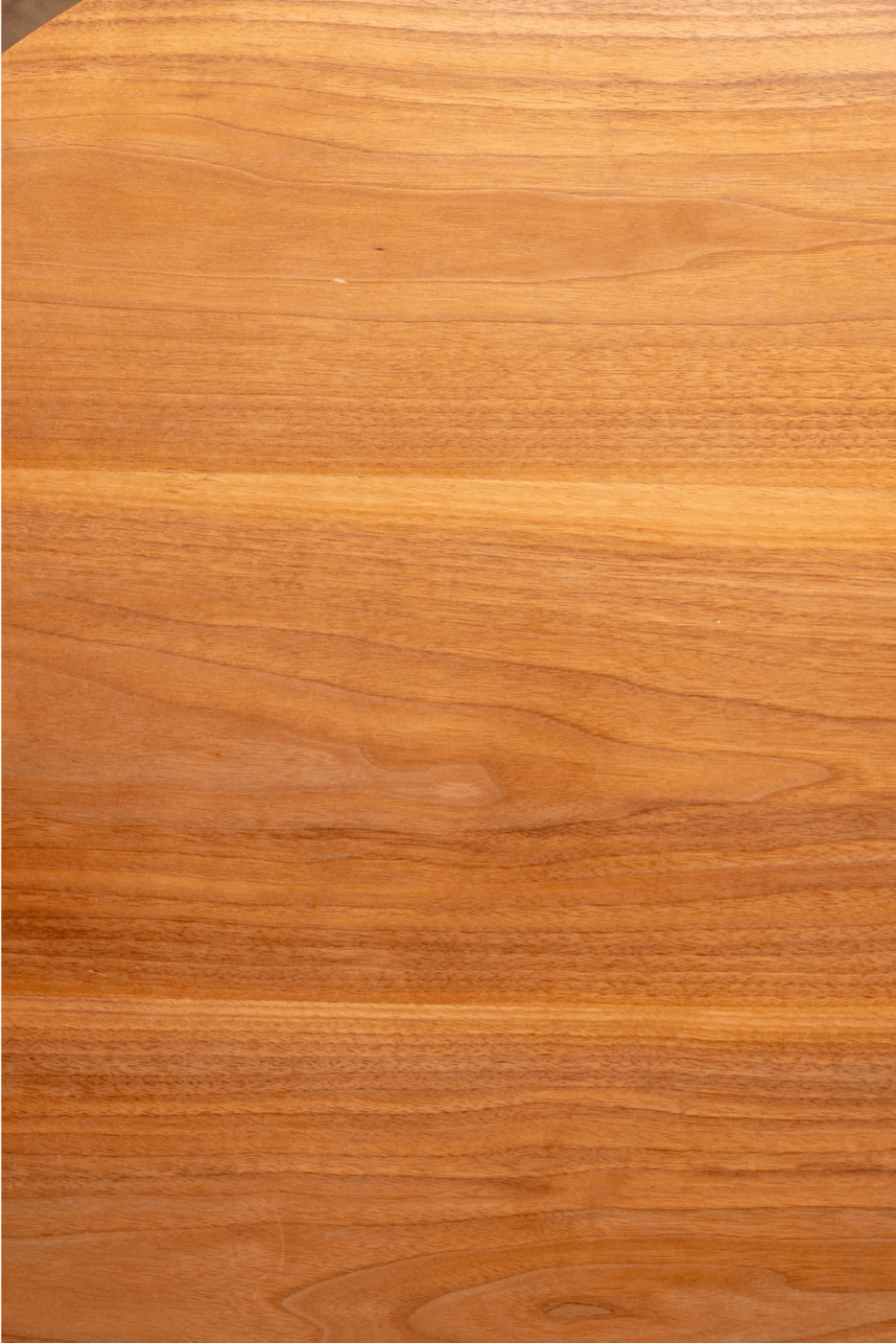 Close-up of a polished wooden surface with visible wood grain and a light brown finish.