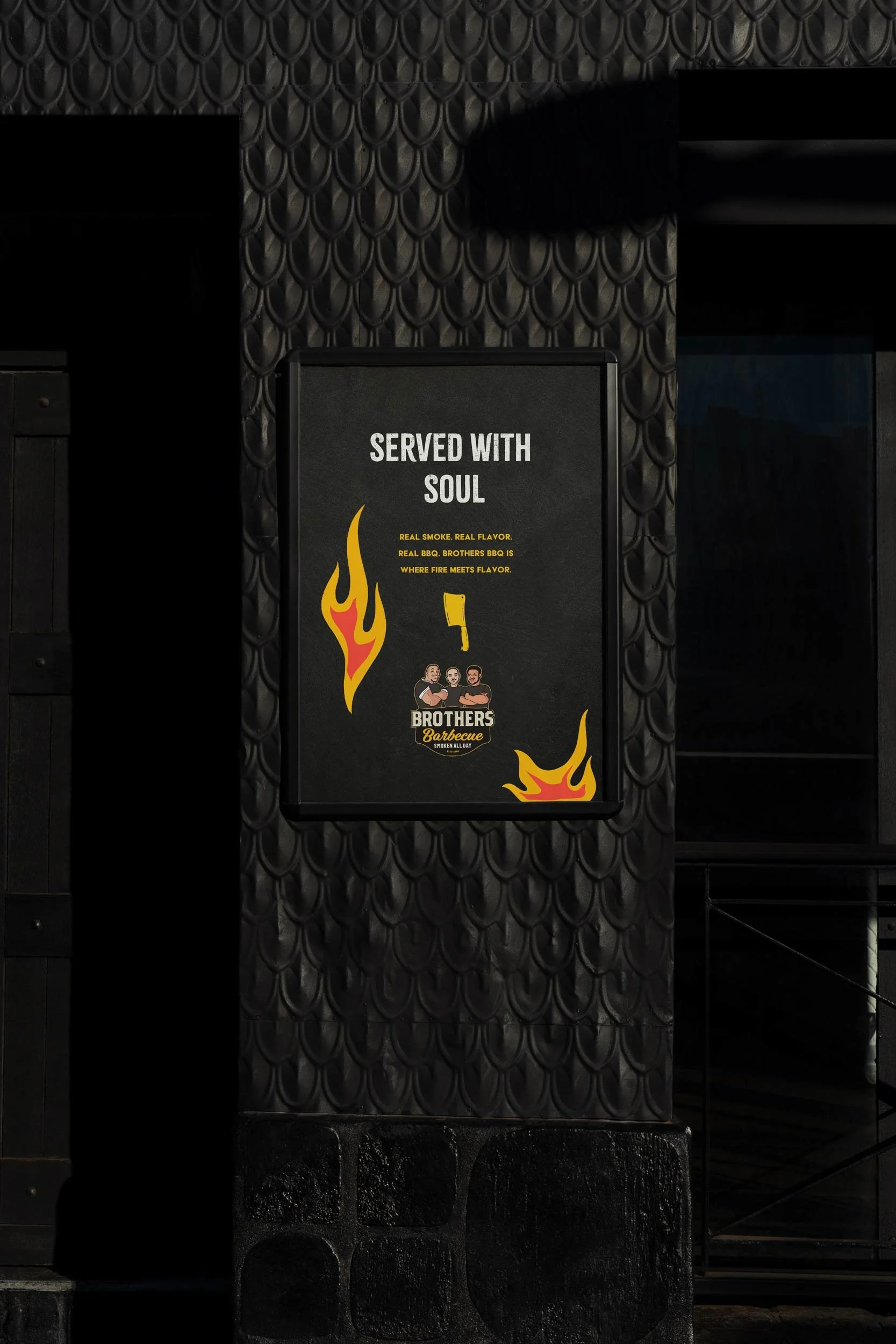 A black sign with yellow flames and images of people, advertising Brothers Barbecue with the slogan "Served with Soul".