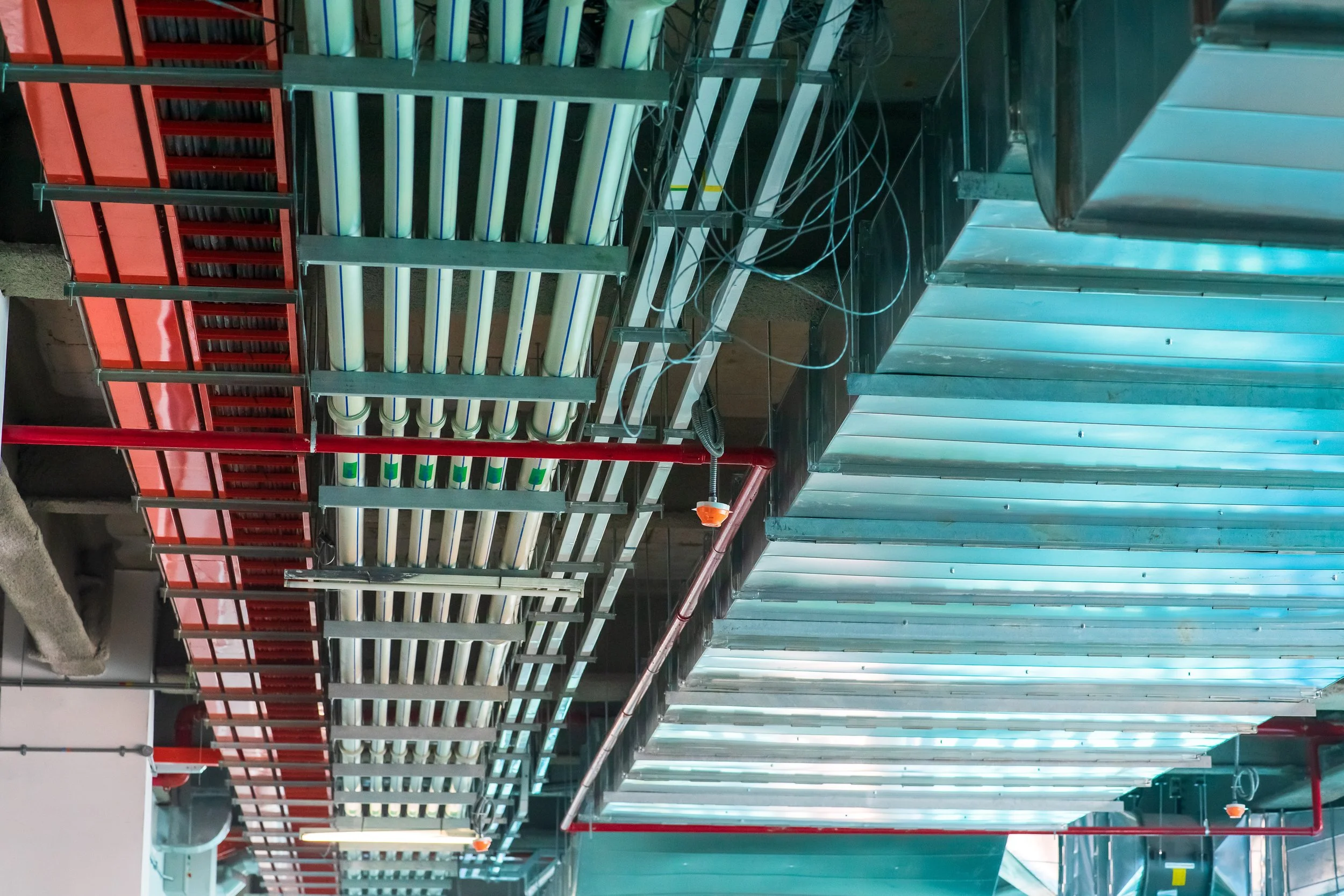 A commercial building in Cle Elum, WA, with exposed ducting and industrial-style lighting visible in the photo. The open ceiling design reveals neatly installed metallic ducts running across the ceiling, alongside rows of modern, suspended lights