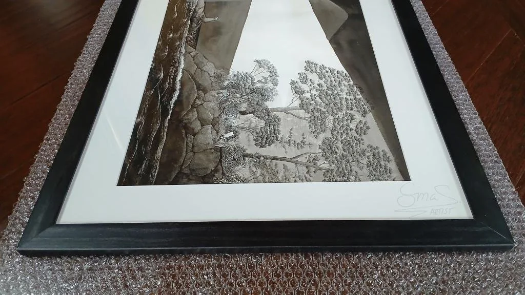 Framed ink drawing titled "The Lighthouse" by New Zealand artist Sina Sibler, featuring a Fiordland crested penguin and fur seal illuminated by a lighthouse beam.
