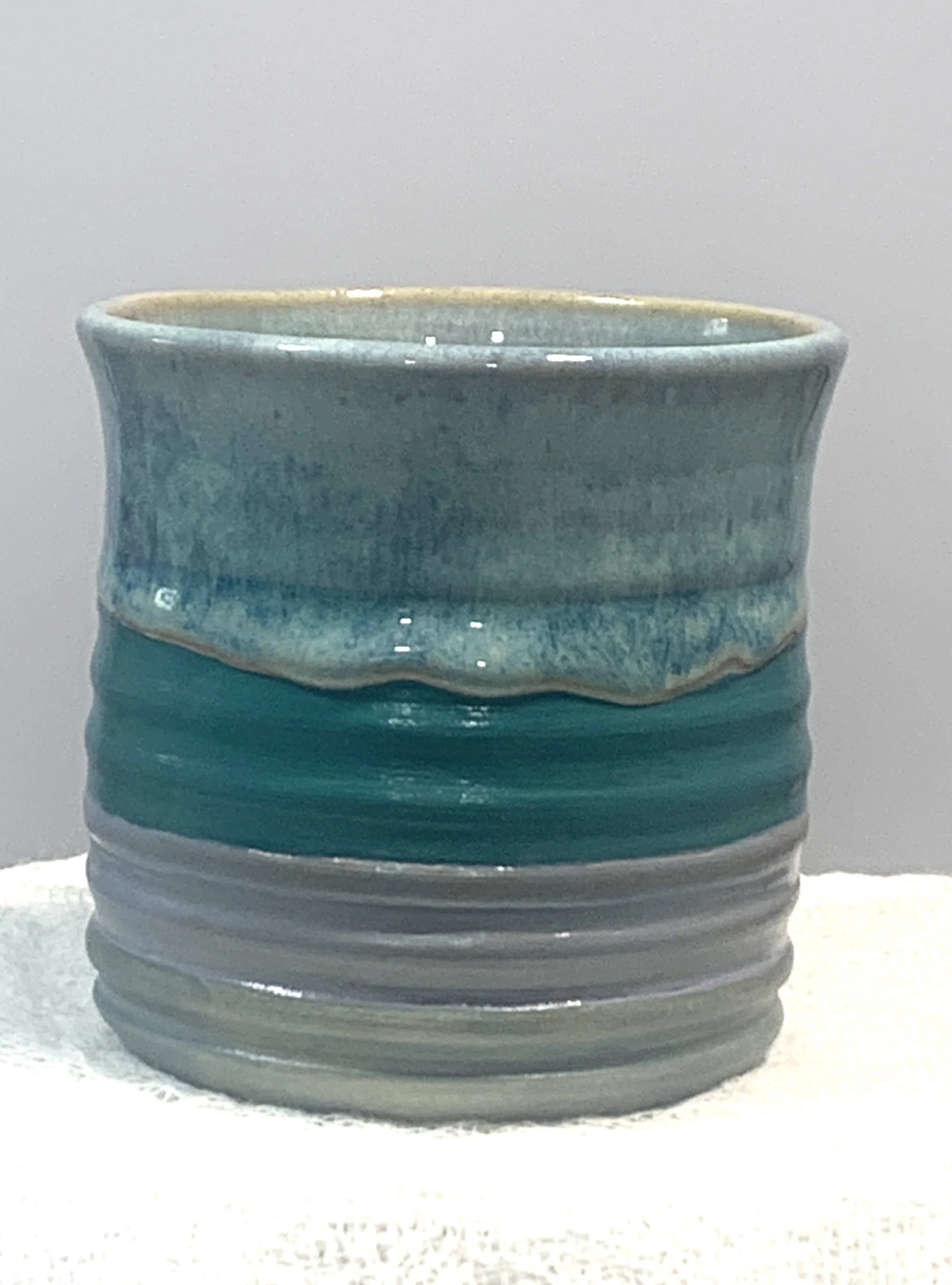 Handmade ceramic mug with a blue glaze and floral design