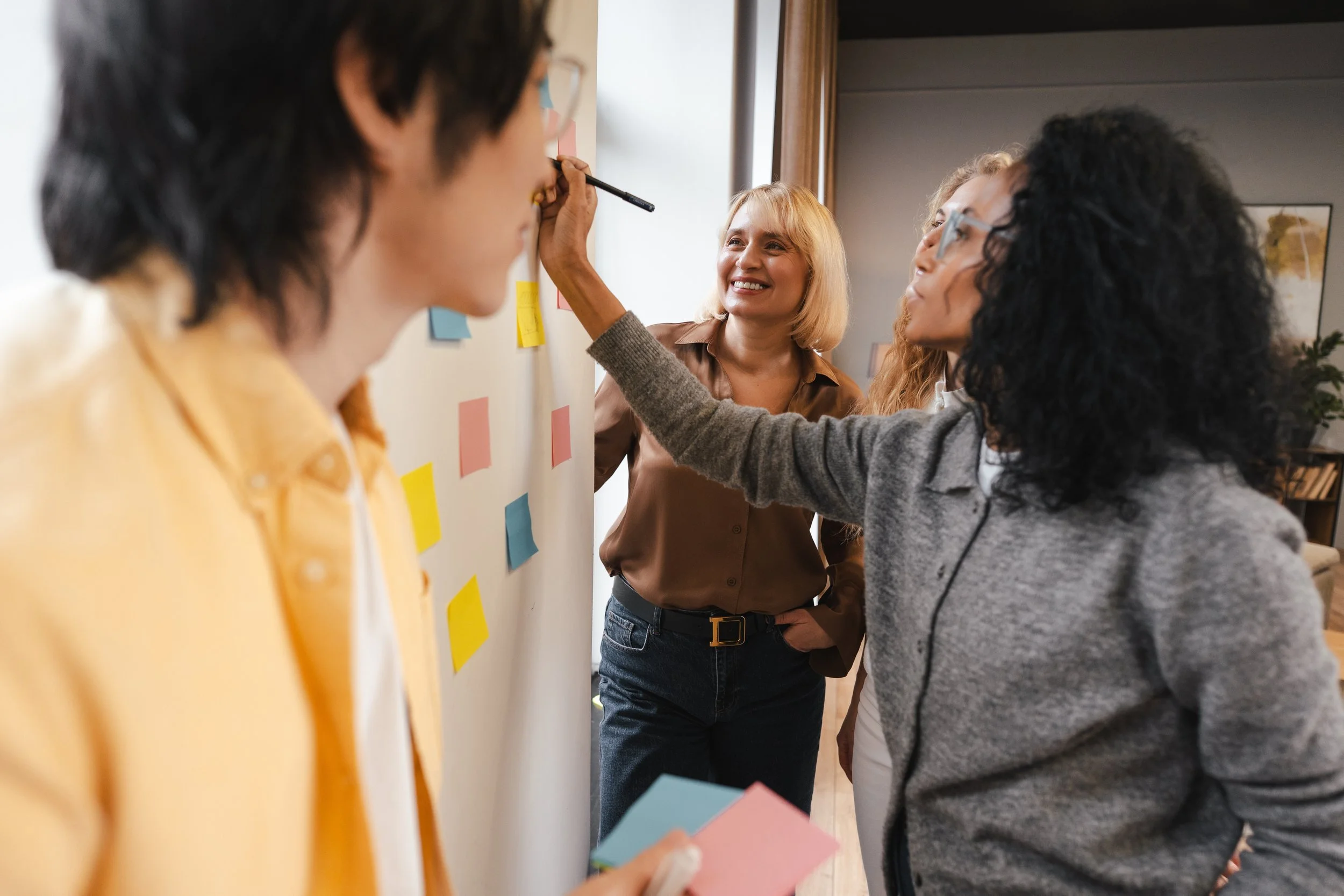 People brainstorming ideas by writing on the whiteboard