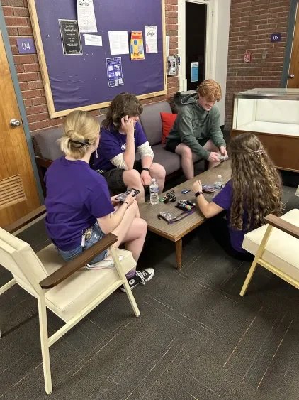 A group of four people sitting around a table, trying to figure out where to get their event's food.