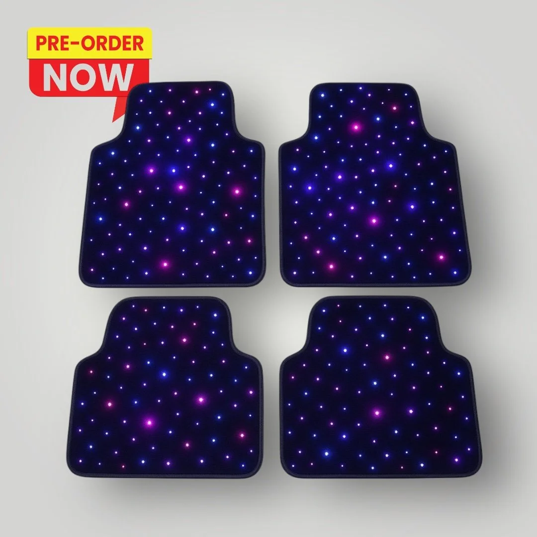 Set of four illuminated car floor mats with purple, blue, and pink LED lights.