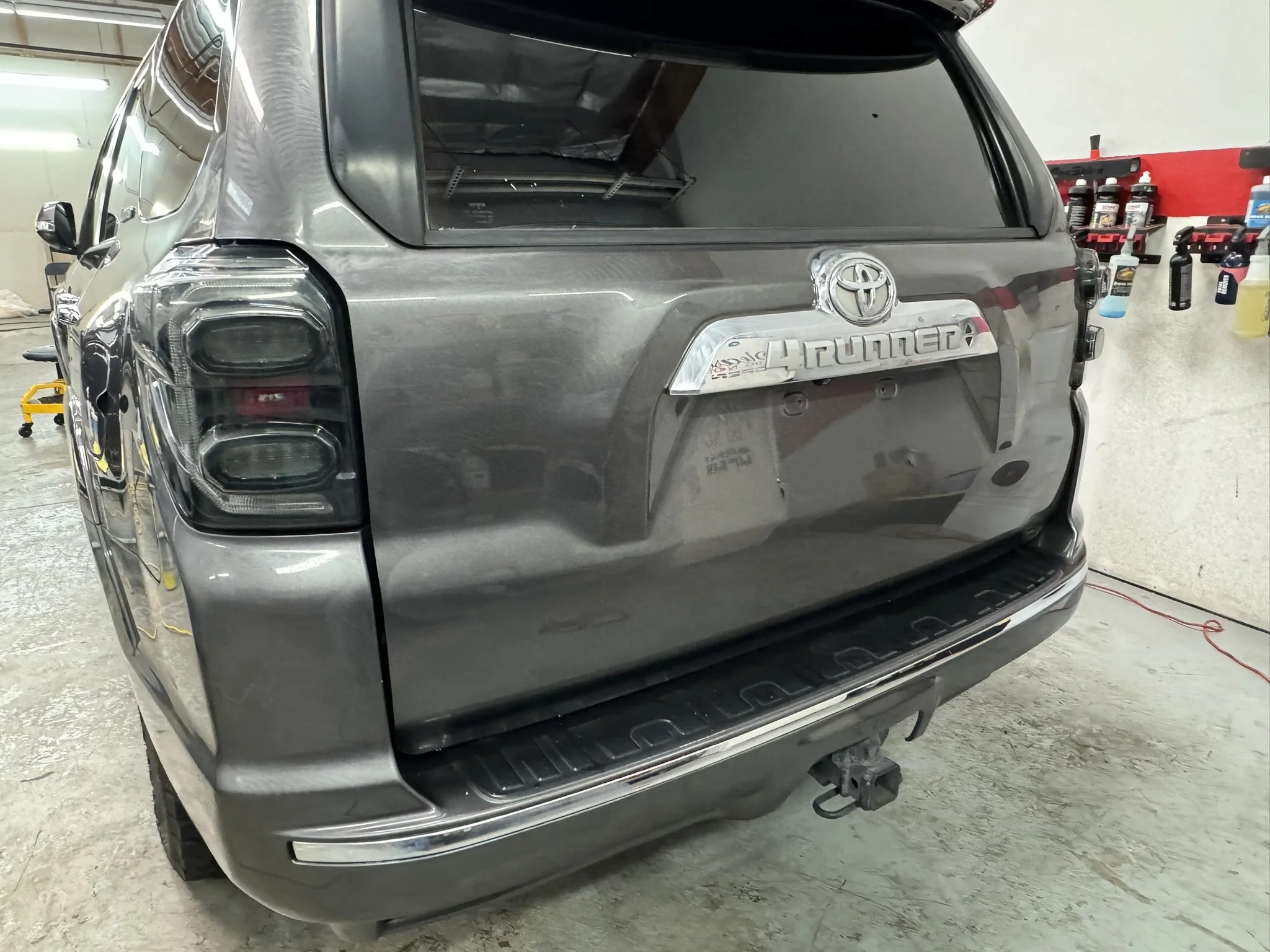Back view of a gray Toyota 4Runner inside a garage, focusing on the rear bumper and taillights.
