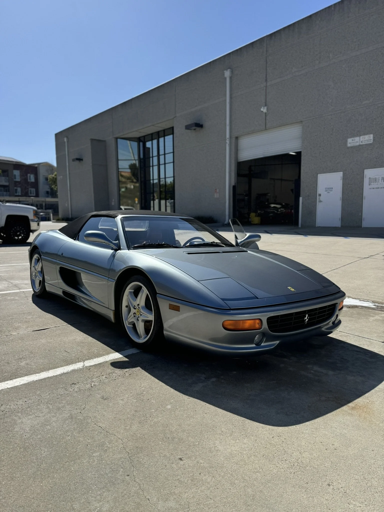 Gray convertible sports car parked outside a building
