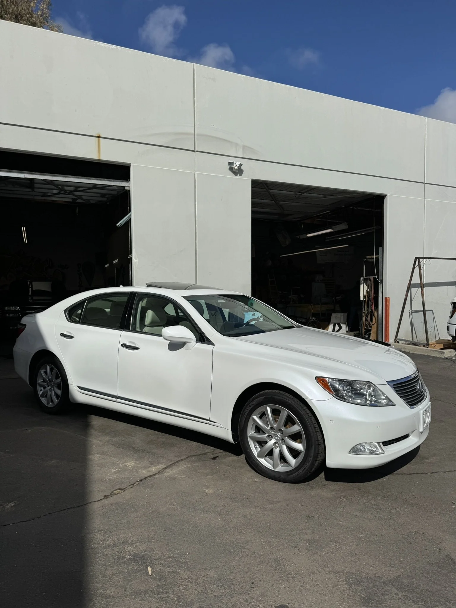 White sedan parked in front of an open garage