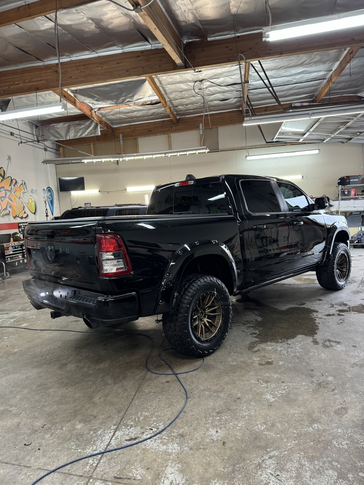 Black pickup truck in garage with custom wheels