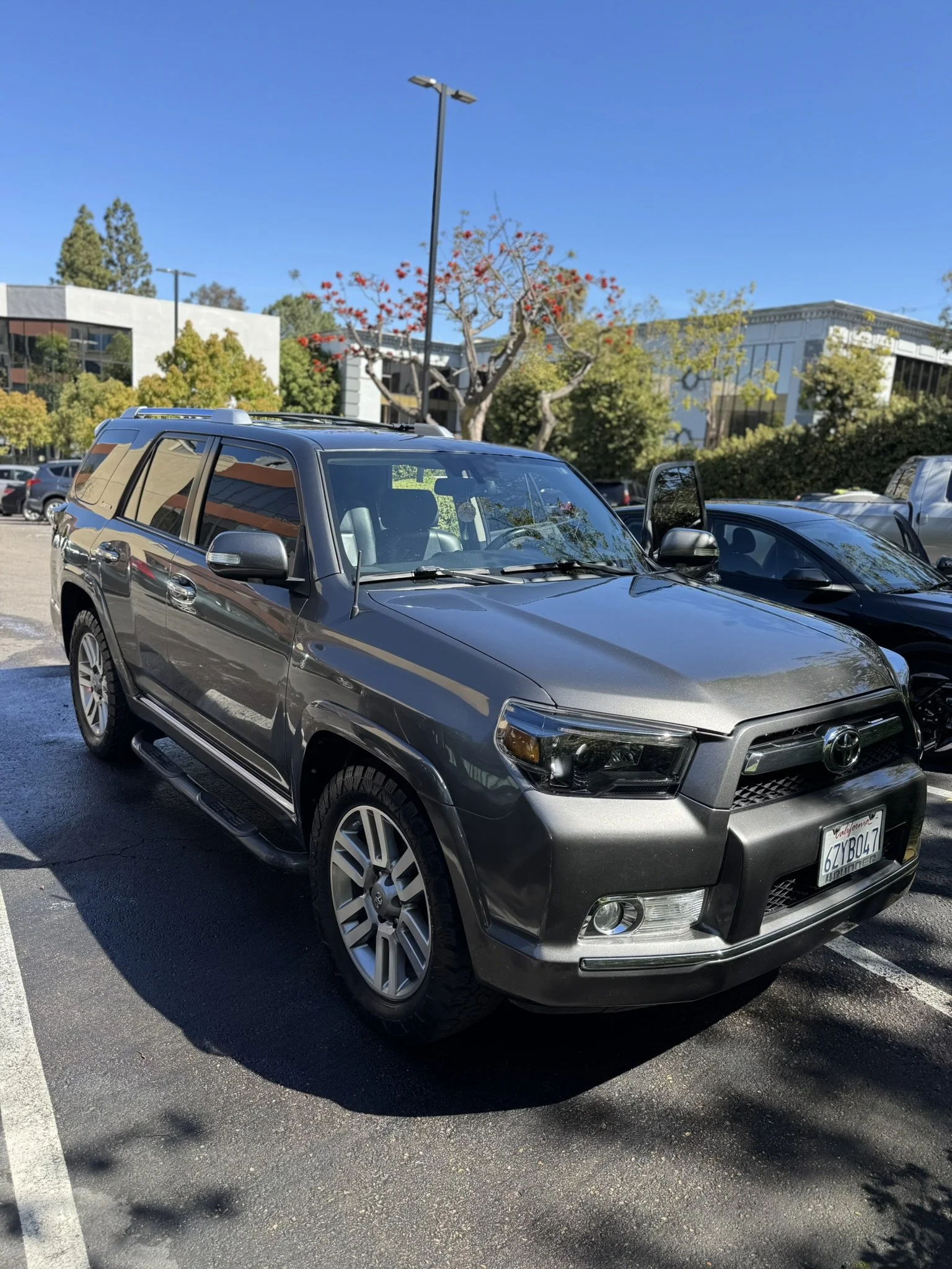 Gray Toyota SUV parked in a parking lot under clear blue sky