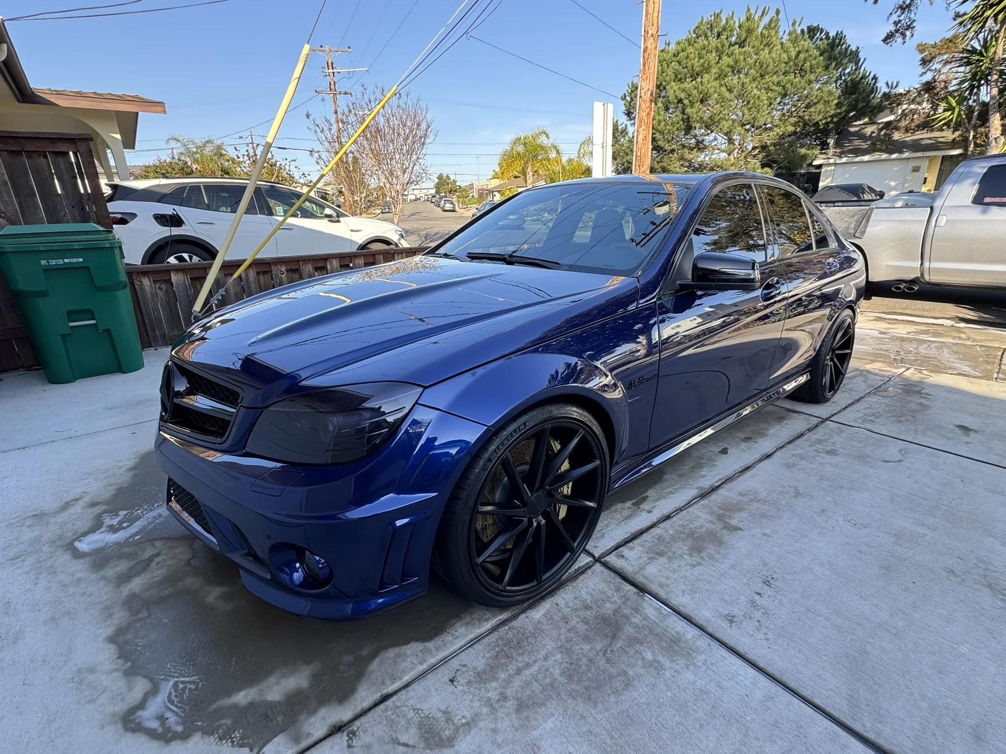 Blue car with black rims parked on a driveway