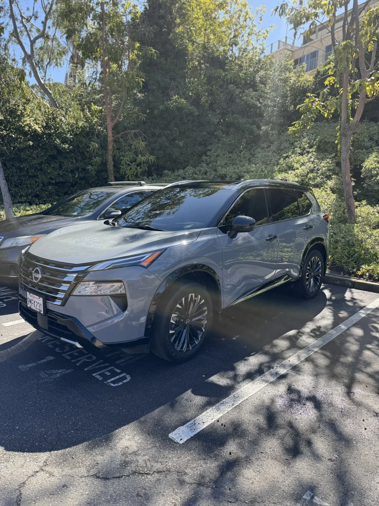 Silver SUV parked in a reserved parking spot in a tree-lined area