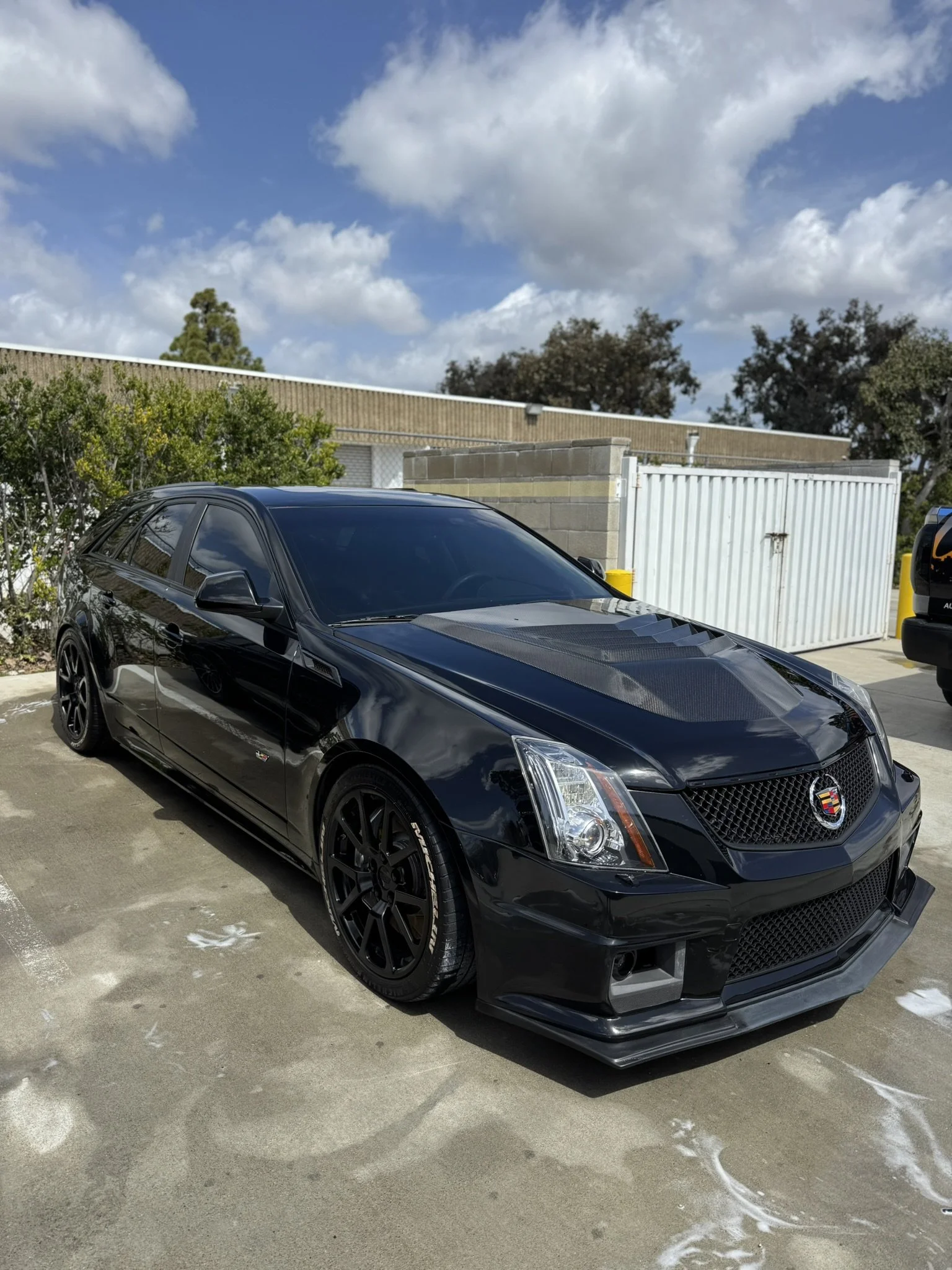 Black Cadillac CTS car parked outdoors on a sunny day.