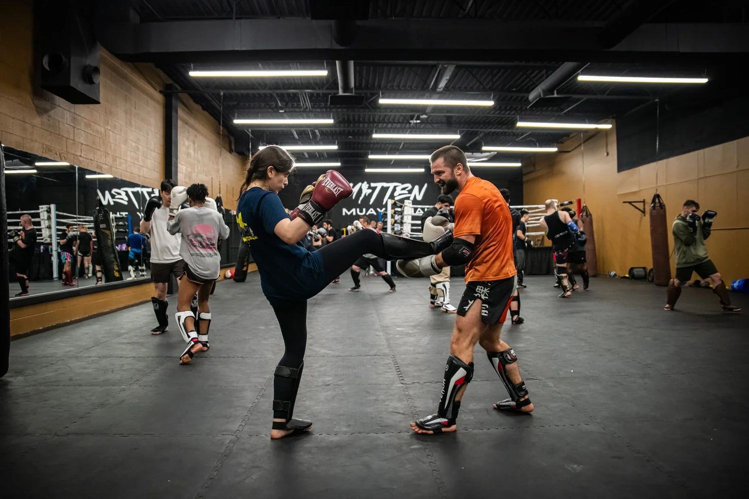 Two members drilling with a partner in shin guards