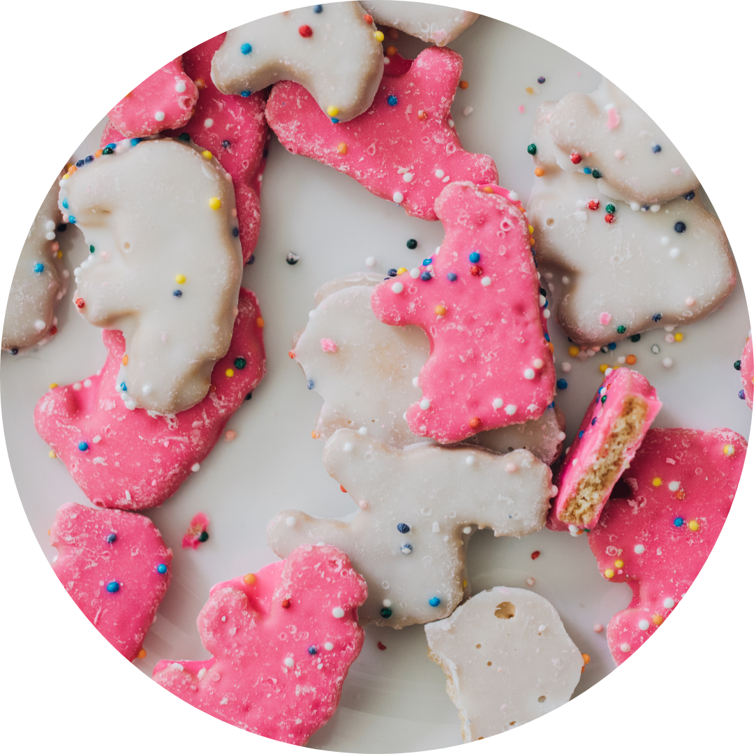 Close-up of pink and white sugar cookies shaped like unicorns, decorated with white icing and colorful sprinkles.
