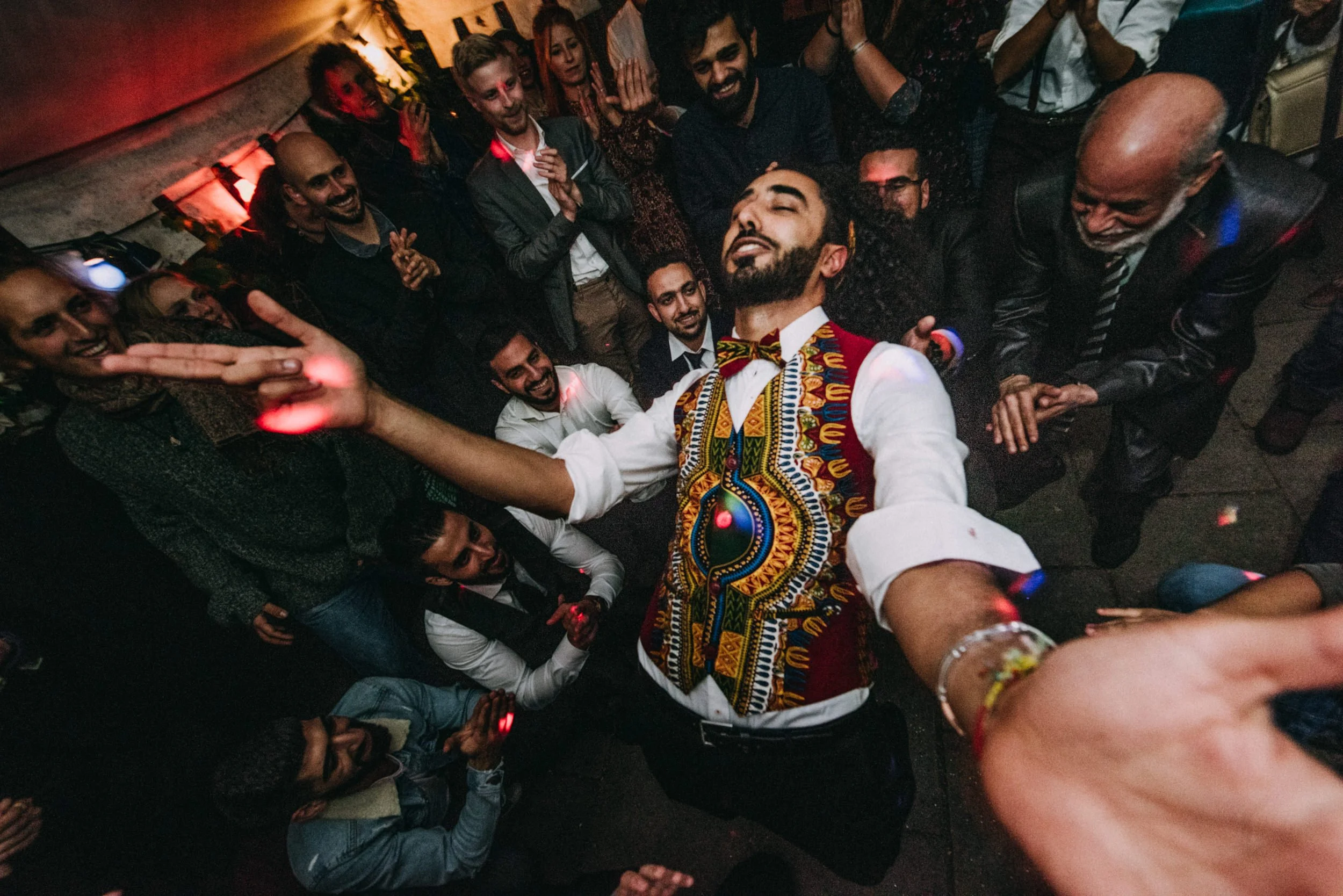 Eine Gruppe von Menschen, die bei einer Party tanzen und Spaß haben, einige lachen und posieren für das Foto.