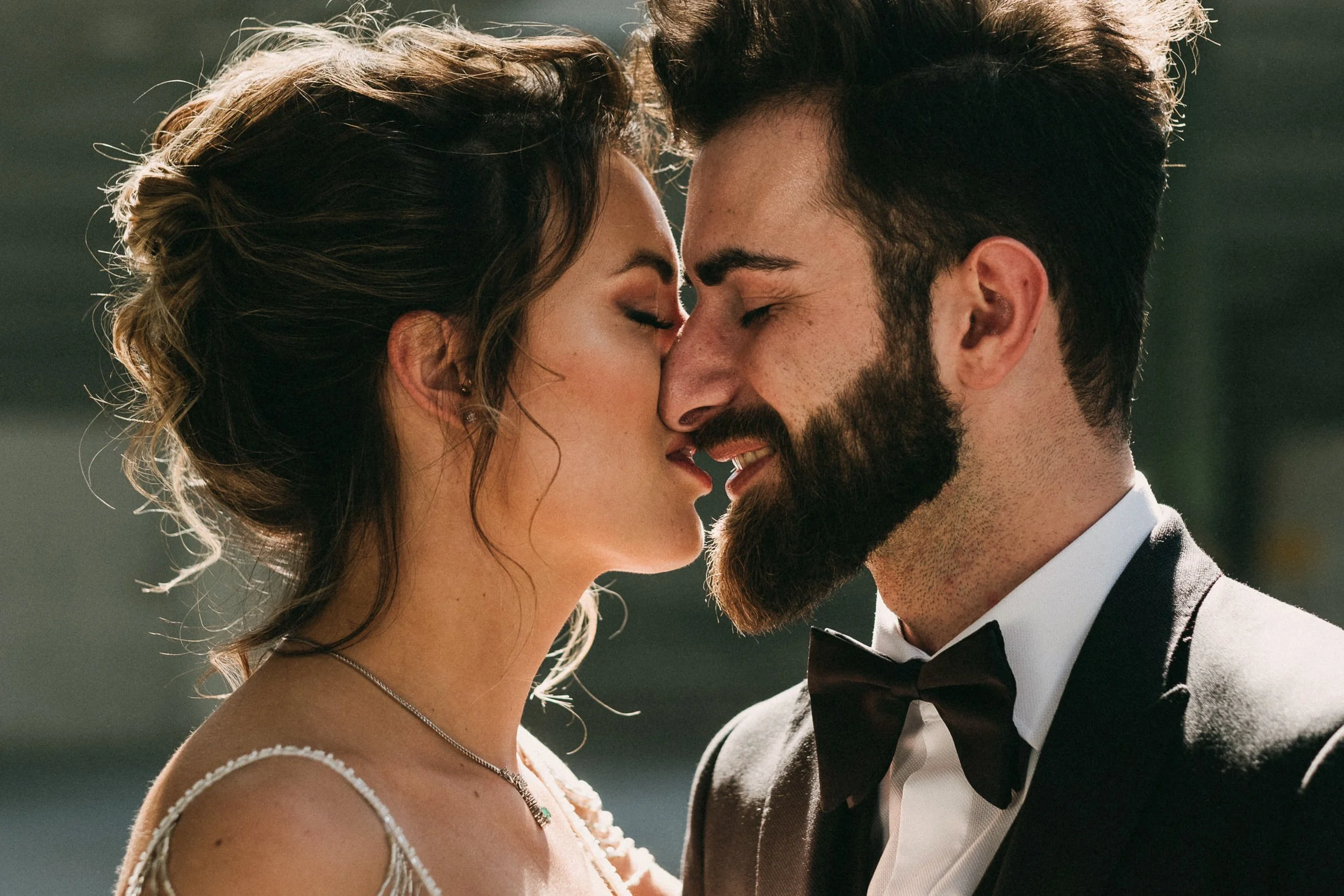 Ein glückliches Paar, das sich bei einer Hochzeit küsst.
