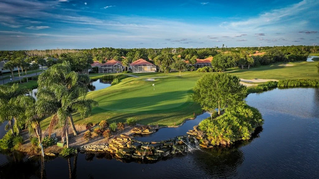 Putting green framed by rock formations, water, and a cascading waterfall at The Club at Lost Lake in Hobe Sound, FL.